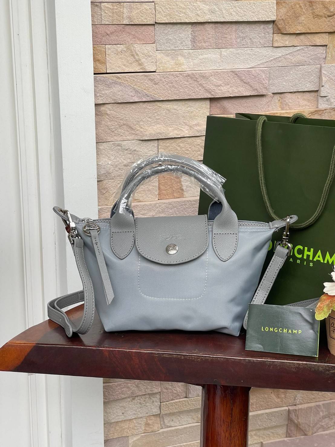 LONGCHAMP LE PLIAGE NÉO TOP HANDLE BAG XS คอลเลคชั่นสุดพิเศษจากลองฌอมป์ มีดีไซน์ที่เรียบหรูและคลาสสิก แฝงด้วยลูกเล่นแบบเฟมินีน แถมยังมีน้ำหนักเบาอย่างไม่น่าเชื่อ มาพร้อมกับหูจับกระเป๋าคู่และฝาปิดแบบกระดุม กระเป๋าถือใบนี้สามารถใช้ถือแบบทั่วไป มีสายสะพายถอด