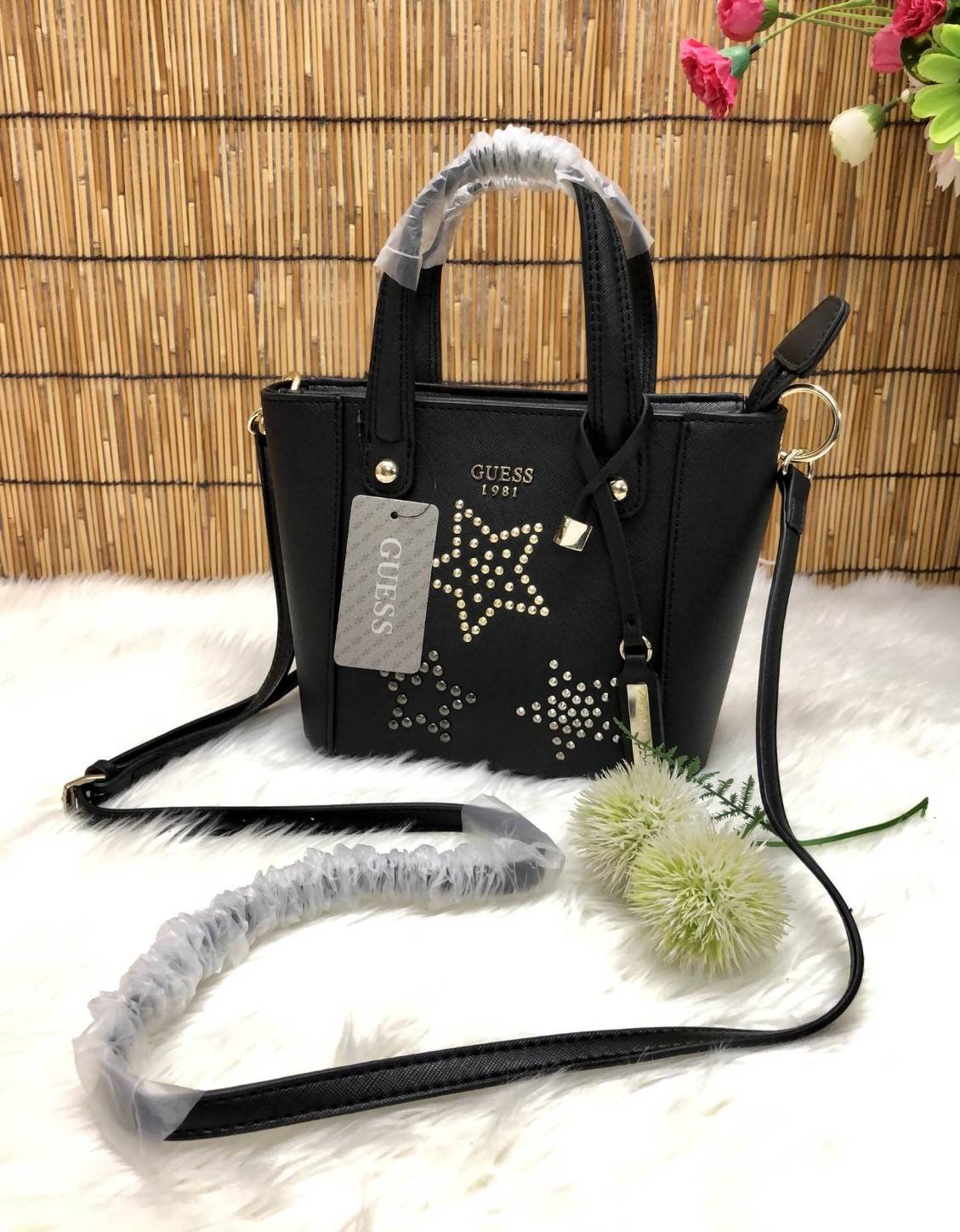 GUESS DELANEY MINI CROSSBODY BAG กระเป๋าถือหรือสะพายข้างได้ วัสดุหนังลาย saffiano ด้านหน้ามีโลโก้แบรนด์ พร้อมตกแต่งรูปดาว และ tag brand ห้อยที่หูกระเป๋า ตัวกระเป๋าเปิดแบบซิป ภายในโล่ง จุได้พอประมาณค่ะ มีช่องซิปอและช่องเล็ก มาพร้อม สายยาวปรับระดับได้ ราคาส