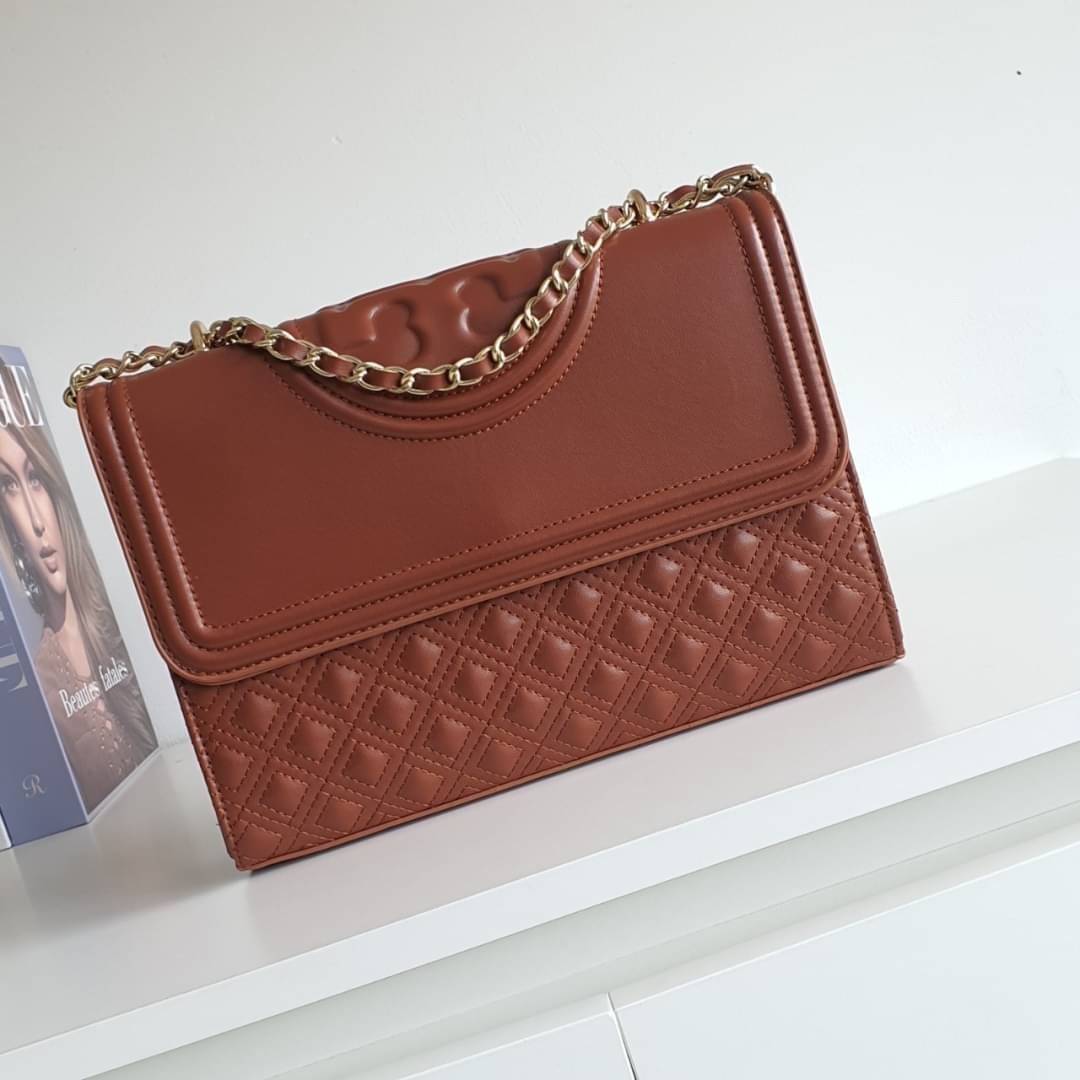 TORY BURCH Fleming Small Convertible Shoulder Bag รุ่นขายดีที่สุดกับ ไอเท็มที่ต้องมีแบรนด์ TORY BURCH มีมาให้ช้อปอีกแล้วค่ะสาวๆ กับทรง CLUCTH & CROSSBODY กระเป๋าสะพายข้างหรือสะพายเป็นครอสบอดี้ ประดับพู่ด้านข้าง