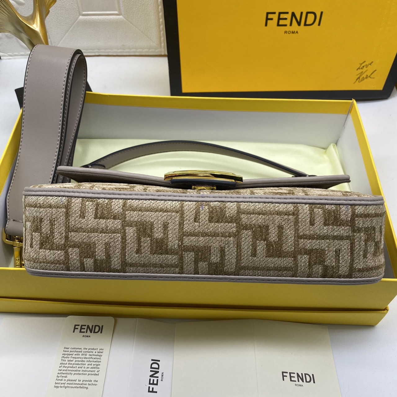 Fendi Baguette FF Tapestry Fabric Bag เกรดออริจินอล กระเป๋าทรง Baguette ขนาดกลาง วัสดุผ้าเซนิล พร้อมลวดลาย FF สีเทาเข้ม ปิดท้ายด้วยรายละเอียดหนังแบบทูโทนและประดับด้วยตัวล็อค FF โดดเด่นด้วยฝาปิดด้านหน้าตัวล็อคแม่เหล็กช่องด้านในบุด้วยผ้าหนังกลับพร้อมกระเป๋า