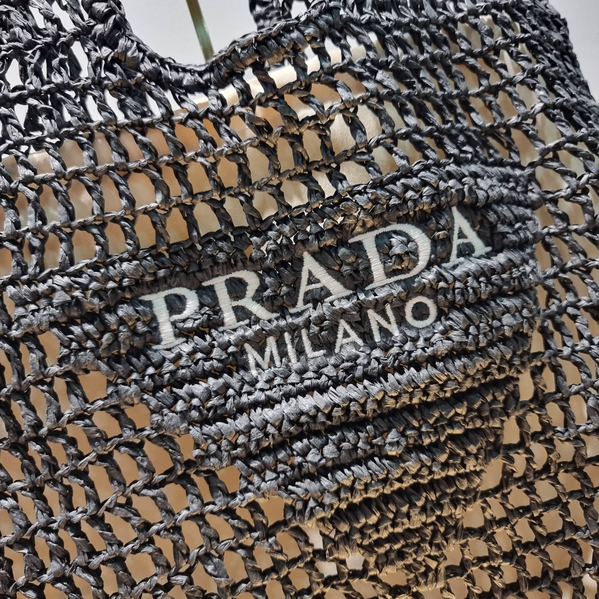 PRADA RAFFIA TOTE BAG สวยไม่ซ้ำใคร สไตล์บีช เหมาะมากกับการสะพายไปเที่ยวทะเล หรือจะใช้ในวันสบายๆก็ตอบโจทย์ กับกระเป๋าสะพายสานใบใหญ่ ตัวกระเป๋าเป็นวัสดุสังเคราห์จากธรรมชาติ