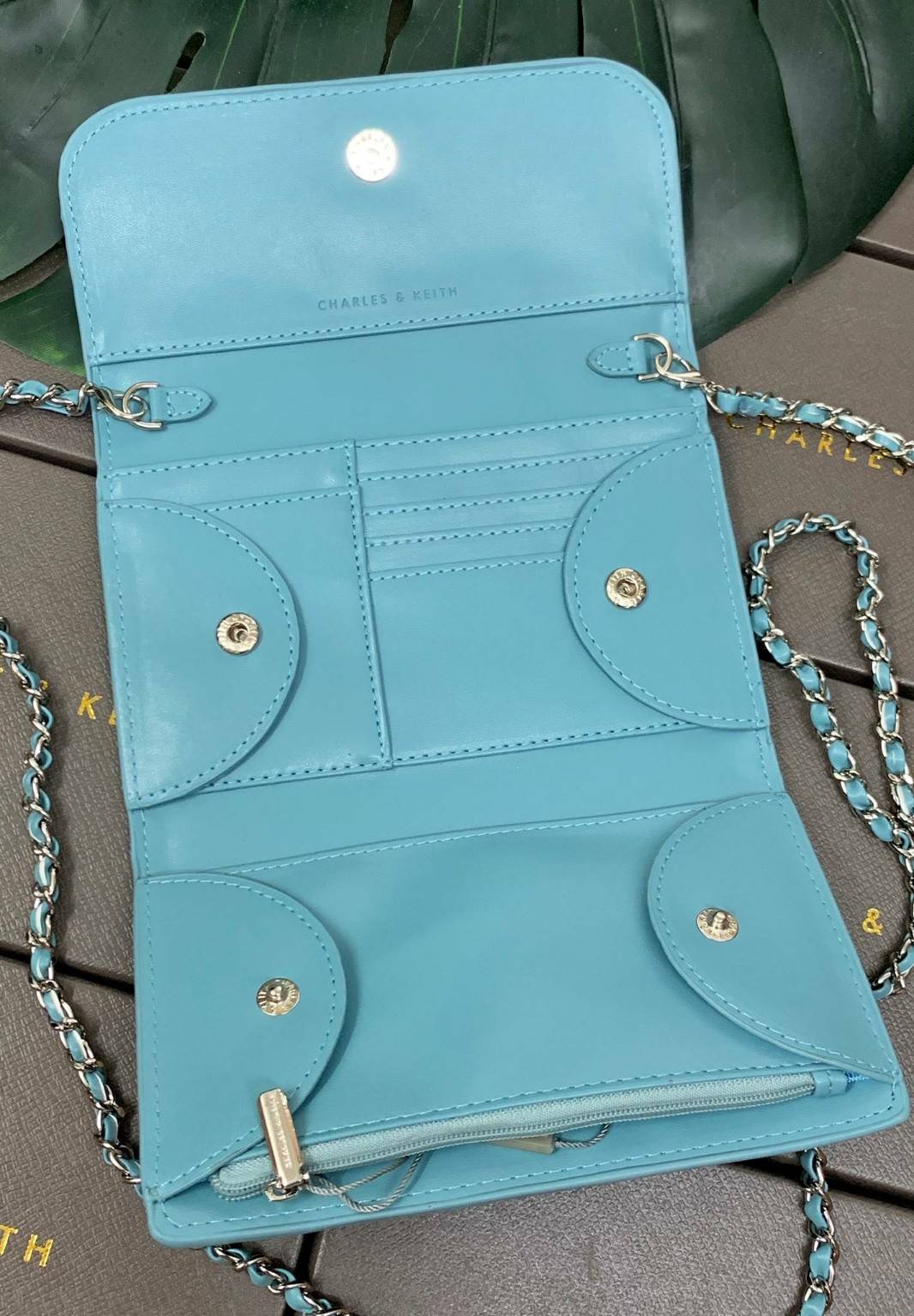 CHARLES & KEITH BAG กลับมาอีกครั้ง รุ่นขายดีค่ะ...กระเป๋าสตางค์มีสายสำหรับสะพายข้างหรือแบบครอสบอดี้ร์ได้ค่ะ วัสดุหนังเรียบ ด้านหน้ามีอะไหล่โลโก้แบรนด์ เปิดปิดกระเป๋าแบบกระดุมแม่เหล็ก ภายในมีช่องใส่ธนบัตร สามารถใส่แบงค์พันได้ค่ะ มีช่องใส่บัตรต่างๆ ช่องซิปส