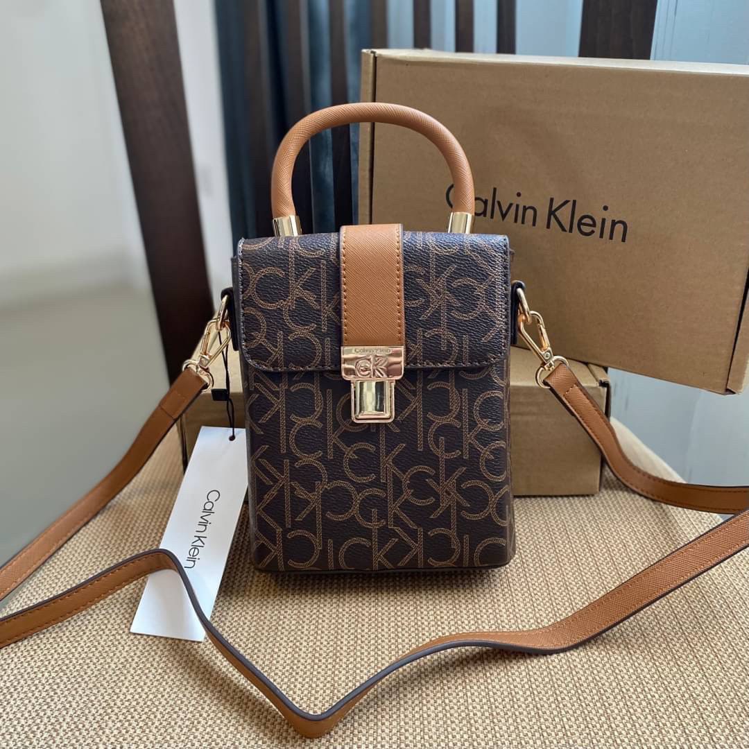 CALVIN KLEIN JEANS crossbody bag กระเป๋าถือหรือสะพาย ลายซิกเนเจอร์แบรนด์ทั้งใบ มีหูจับสำหรับถือ เปิด-ปิดกระเป๋าด้วยกระดุมแม่เหล็ก ด้านในโล่งกว้างมีช่องเล็กและช่องซิปสำหรับใส่ของจุกจิก ซับในลายแบรนด์อย่างดี มาพร้อมสายสะพายยาวปรับระดับได้ สามารถใช้ได้หลากหล