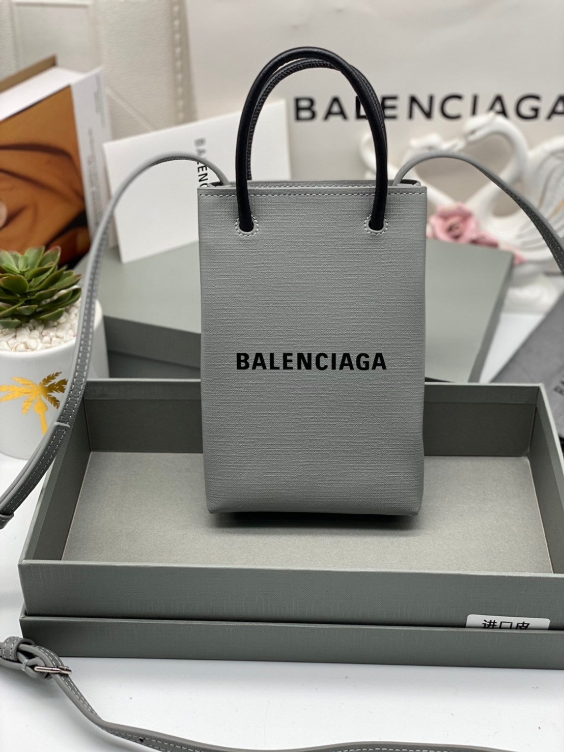 หนังแท้ BALENCIAGA Shopping Phone Pouch leather tote พกกระเป๋าช้อปปิ้งขนาดมินิ ไปทุกที่ในฤดูกาลนี้ ดีไซน์ที่ใช้ได้ทุกวันตั้งแต่หนังแบบมีเท็กซ์เจอร์ ภาพสินค้าถ่ายจากงานขายจริง ใช้งานต่างประเทศได้