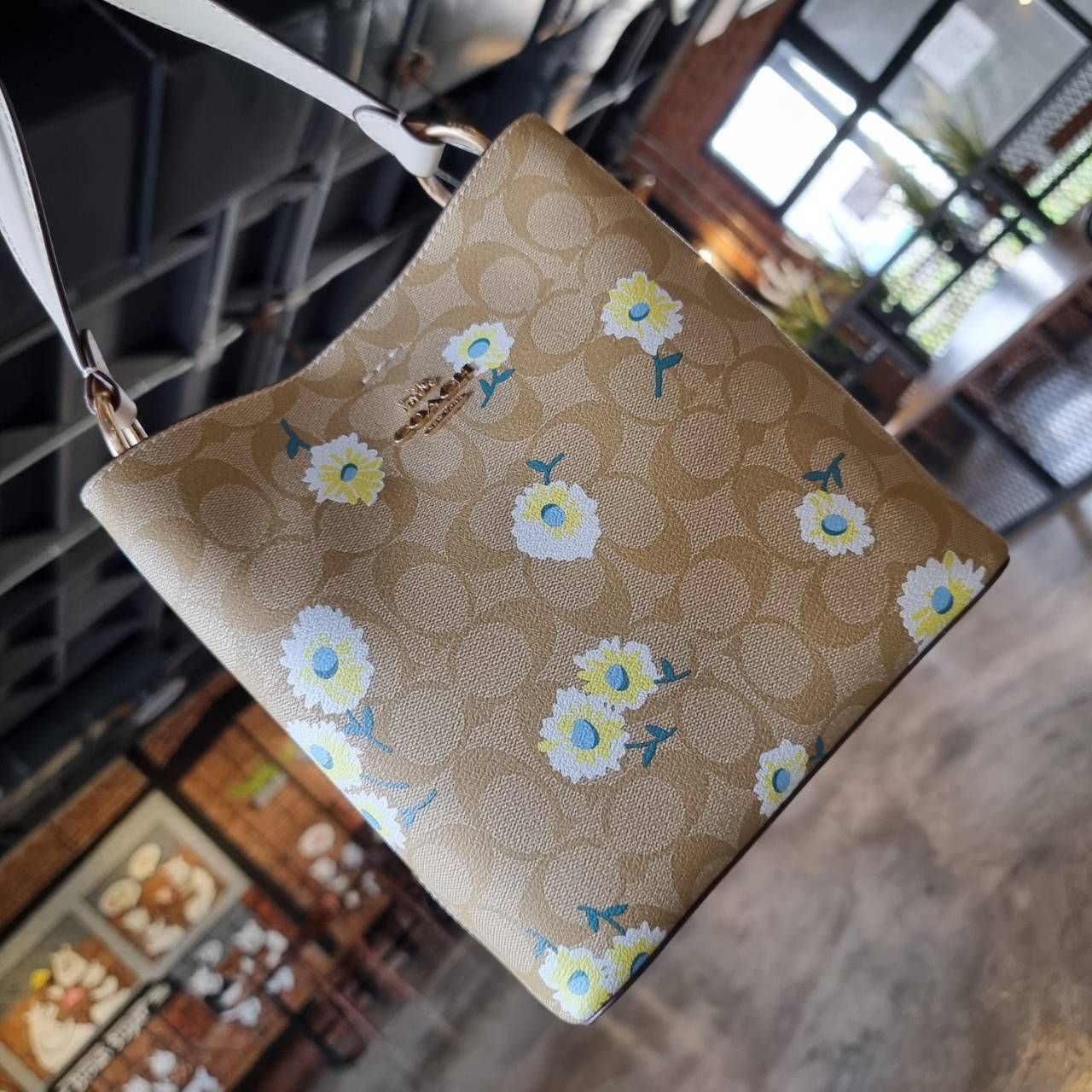 OUTLET 】COACH C3411 SMALL TOWN BUCKET BAG IN SIGNATURE CANVAS WITH DAISY PRINT สวยสดใสมาให้ถึงบ้านจ้า!! กระเป๋าทรงบัคเก็ตยอดฮิต รอบนี้น่ารักมุ้งมิ้งไม่เลิก ดีไซน์ลายดอกเดซี่คละรอบใบ วัสดุหนังแคนวาสเคลือบลาย ปากกระเป๋าเปิด-ปิดด้วยกระดุมแม่เหล็ก 2ฝั่ง มีหูจ