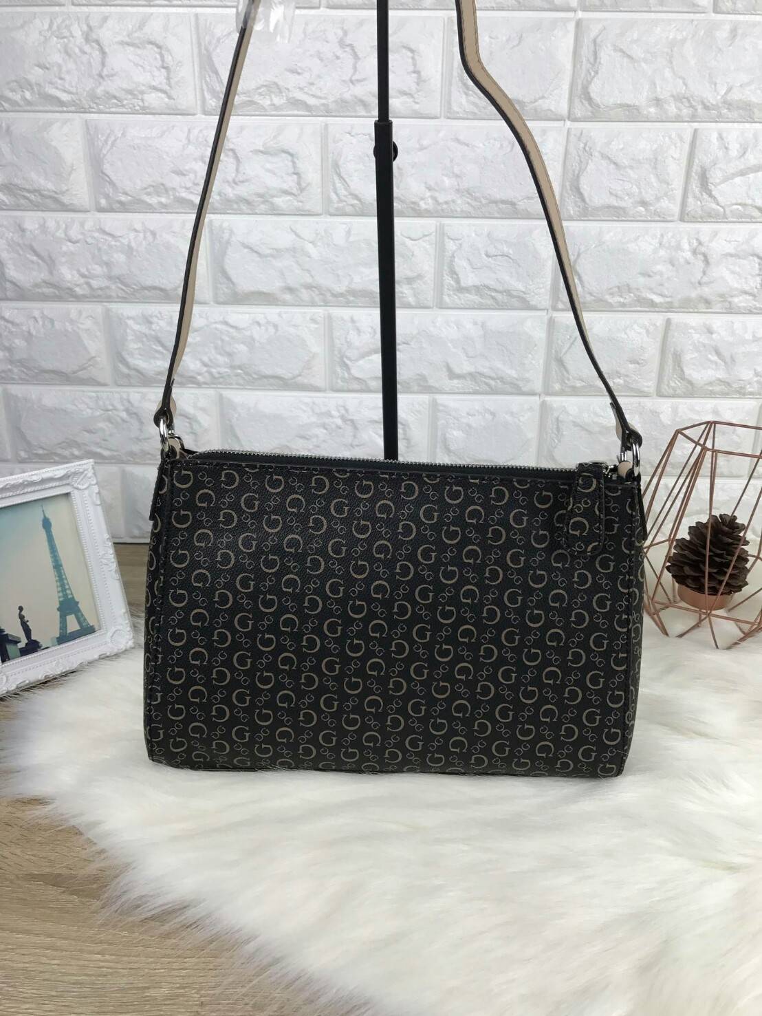 GUESS CROSSBODY BAG กระเป๋ารุ่นนิยม รุ่นนี้สวยเก๋มากๆ มีลายแบรนด์ตัดกับหนังเรียบสวยงาม พร้อมโลโก้แบรนด์สีเงินสวยเด้น มาพร้อมพวงกุญแจหนังเป็นพู่ๆ ประดับข้างๆ เปิดปิดด้วยซิปบน ด้านนายมีช่องใส่โทรศัพท์ และช่องอื่นๆ รุ่นนี้สามารถใส่กระเป๋าเงินใบยาวได้ ของจุกจ