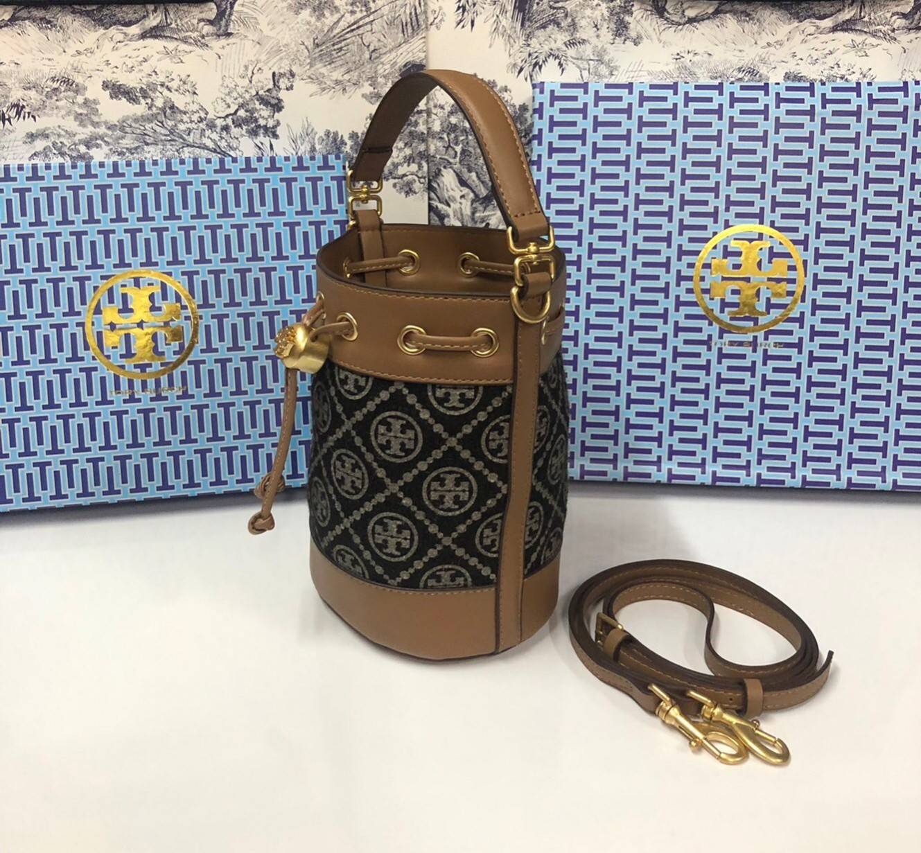 Mini : Tory Burch T Monogram Chenille Bucket Bag เปิดตัวอีกหนึ่งรุ่นกับกระเป๋าลาย T MONOGRAM รุ่นใหม่ล่าสุดจาก TORY BURCH พลาดไม่ได้กับโลโก้สุดคลาสสิก ลวดลาย T Monogram คือวัสดุ chenille หรือที่เรียกว่า ด้านไหมกำมะหยี่ มารังสรรค์ลงบนกระเป๋าBucketใบนี้ เป็