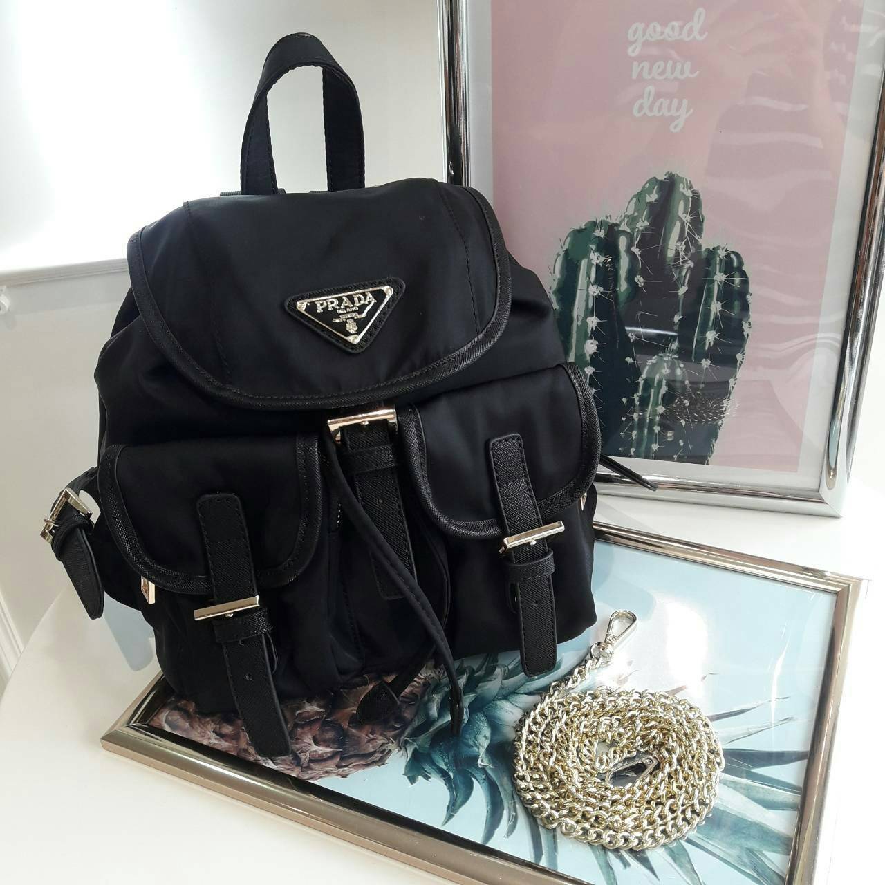PRADA MINI BACKPACK with chain กระเป๋าเป้ size mini premium gift จากแบรนด์ Prada ขนาดกำละงน่ารัก ปรับสะพายได้หลายทรง วัสดุ nylon เปิดปิดด้วยกระดุมแม่เหล็ก ด้านหน้ามีช่องเล็ก น้ำหนักเบา ภายในมีช่องเล็ก และช่องซิป จุได้เยอะ ซับได้ 100& polyester มีหูหิ้วจับ