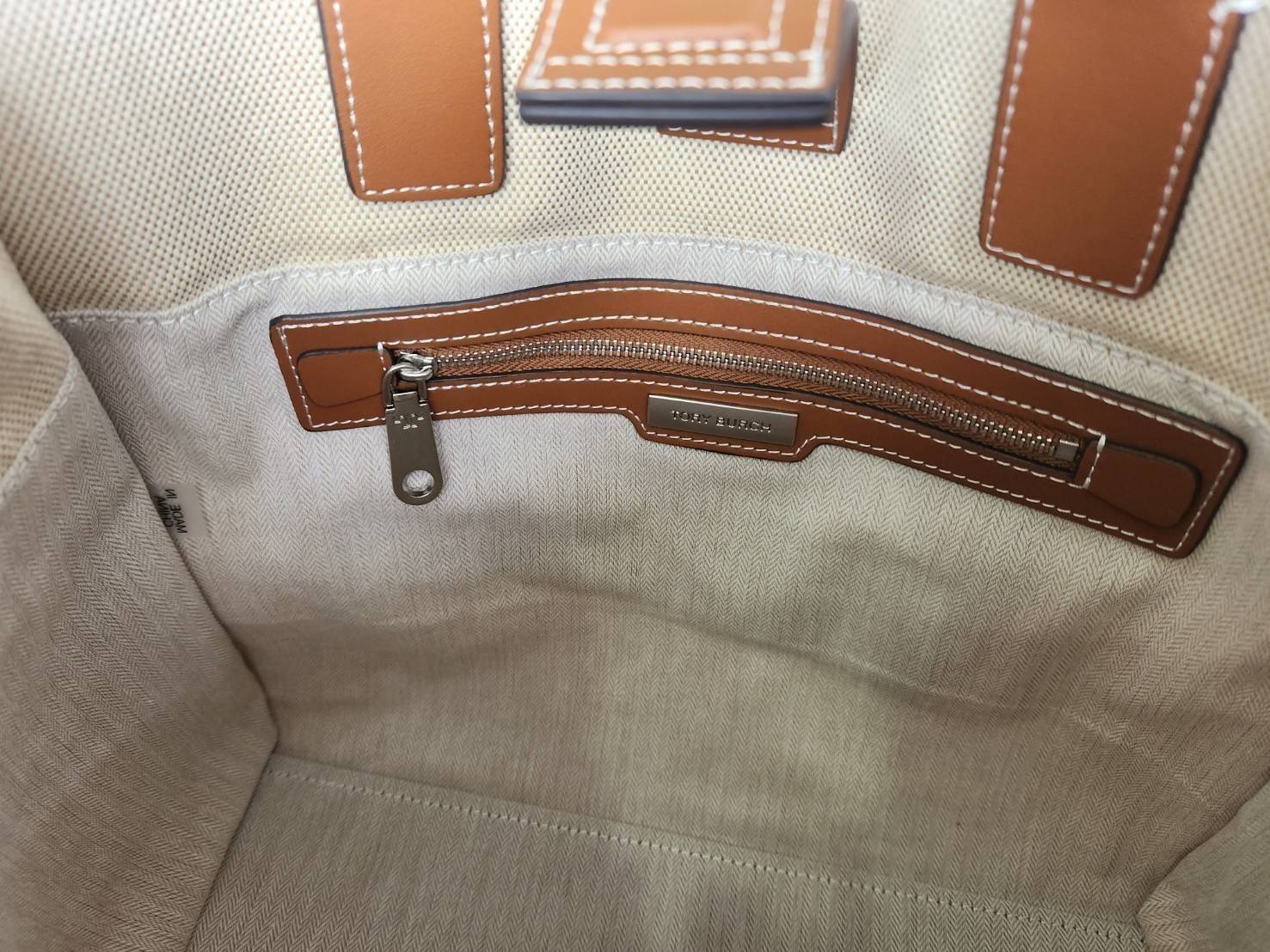 TORY BURCH ELLA CANVAS TOTE BAG กระเป๋าโท้ตน้ำหนักเบาของเราพร้อมป้ายโลโก้ Ella ทำจากผ้าใบที่ทนทานพร้อมรายละเอียดหนังและกระเป๋าด้านใน อเนกประสงค์ ทรงคลาสสิก และสร้างขึ้นอย่างสวยงามด้วยฝีมือช่างฝีมือ สายรัดแคบช่วยให้วางราบกับไหล่ได้อย่างสบาย เหมาะสำหรับทุกว