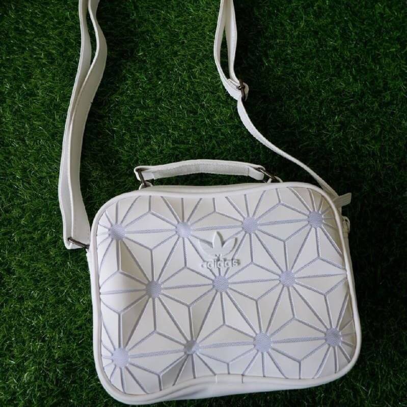 adidas mini airline bag *outlet* กระเป๋าสะพายข้างทรงสปอร์ต ด้านหน้าติดโลโก้แบรนด์ ดีไซน์ลาย 3D ด้านหลังเป็นหนังเรียบ มีช่องซิปสามารถใส่สิ่งของได้ รุ่นนี้เปิดปิดด้วยซิปคู่ ซิปปั๊มแบรนด์ทุกจุด ด้านในเป็นช่องกว้าง มีช่องซิป สายสะพายยาวสามารถปรับระดับได้ สาวก