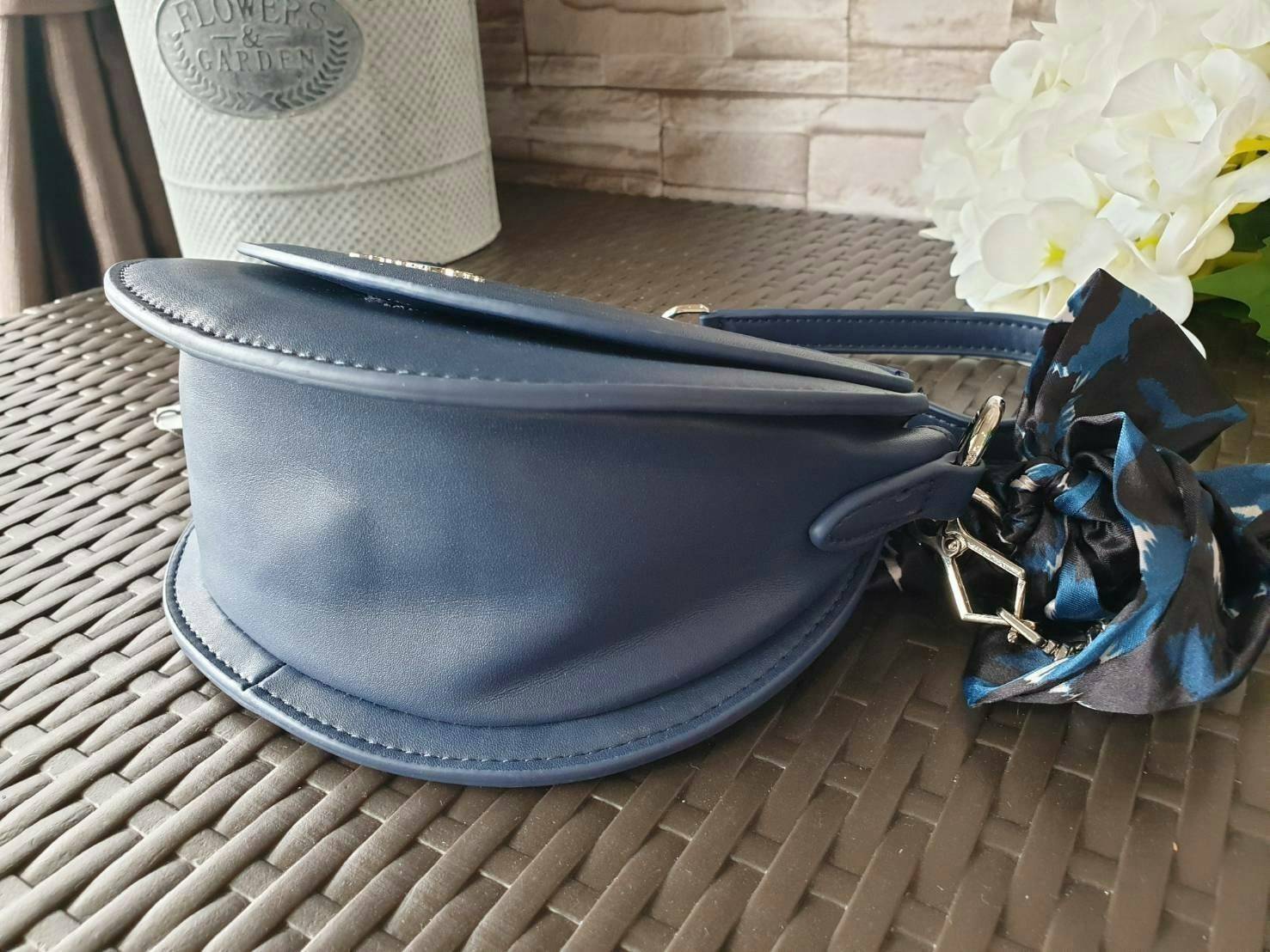 CHARLES & KEITH รุ่น LEATHER SATIN SCARF CROSSBODY BAG SL2-50150828 ราคาปกติช้อป ( ฿3,590.00 ) กระเป๋าถือ และ สะพาย ทรงโค้งมน หนังเรียบ ตั้งอยู่ทรง ด้านหน้าติดโลโก้แบรนด์ อะไหล่เงิน หูจับสายกระเป๋าร้อยเข้ากับห่วงเหล็กกลมๆ ด้วยผ้าลายสวยงามผูกเป็นโบว์เก๋ๆ ถ