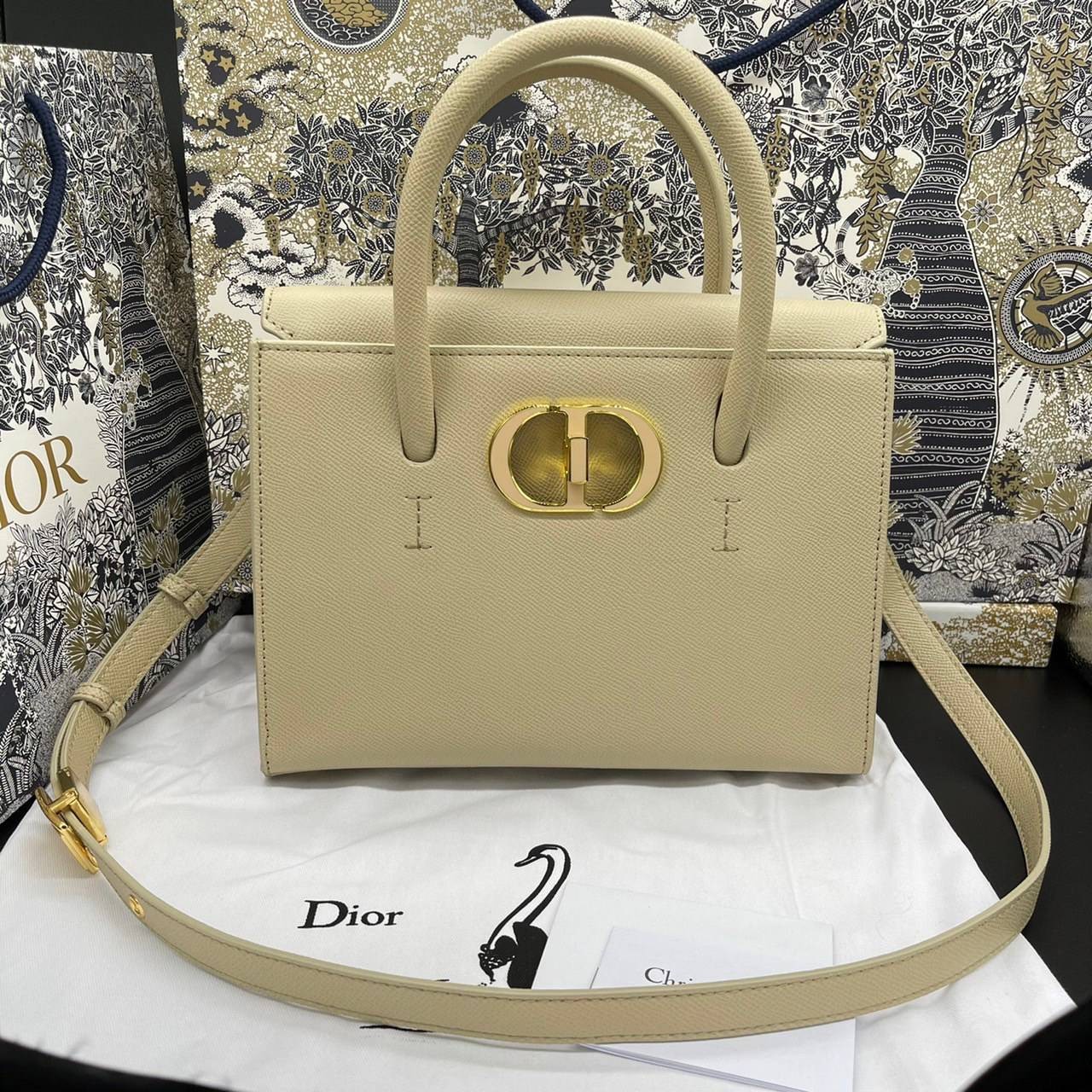หนังแท้ DIOR Medium ST Honore Tote Collection Fall/Winter 2020-2021 มาในรูปแบบกระเป๋าทรงสี่เหลี่ยมที่ได้มาตรฐาน ทำจากหนังลูกวัว (Calfskin) ลายเกรน ซึ่งสื่อถึงความหรูหราได้อย่างลงตัว ตัวด้ามจับ มีการเย็บเข้าด้านในของกระเป๋าเพื่อเพิ่มความแข็งแรงทนทาน ด้านหน