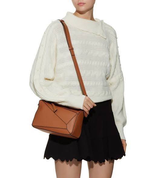 Loewe Puzzle Bag In Classic กระเป๋าทรง Puzzle นี้ออกแบบโดย Jonathan Anderson โดยได้รับแรงบันดาลใจในการออกแบบมาจากรูปทรงของลูกรักบี้ ดังนั้น จึงจะเห็นได้ว่าการตัดเย็บและรูปทรงของกระเป๋านั้นคล้ายคลึงกับลูกรักบี้ รูปทรงดูมินิมอลไม่ทิ้งคอนเซ็ปต์ของแบรนด์ สามา