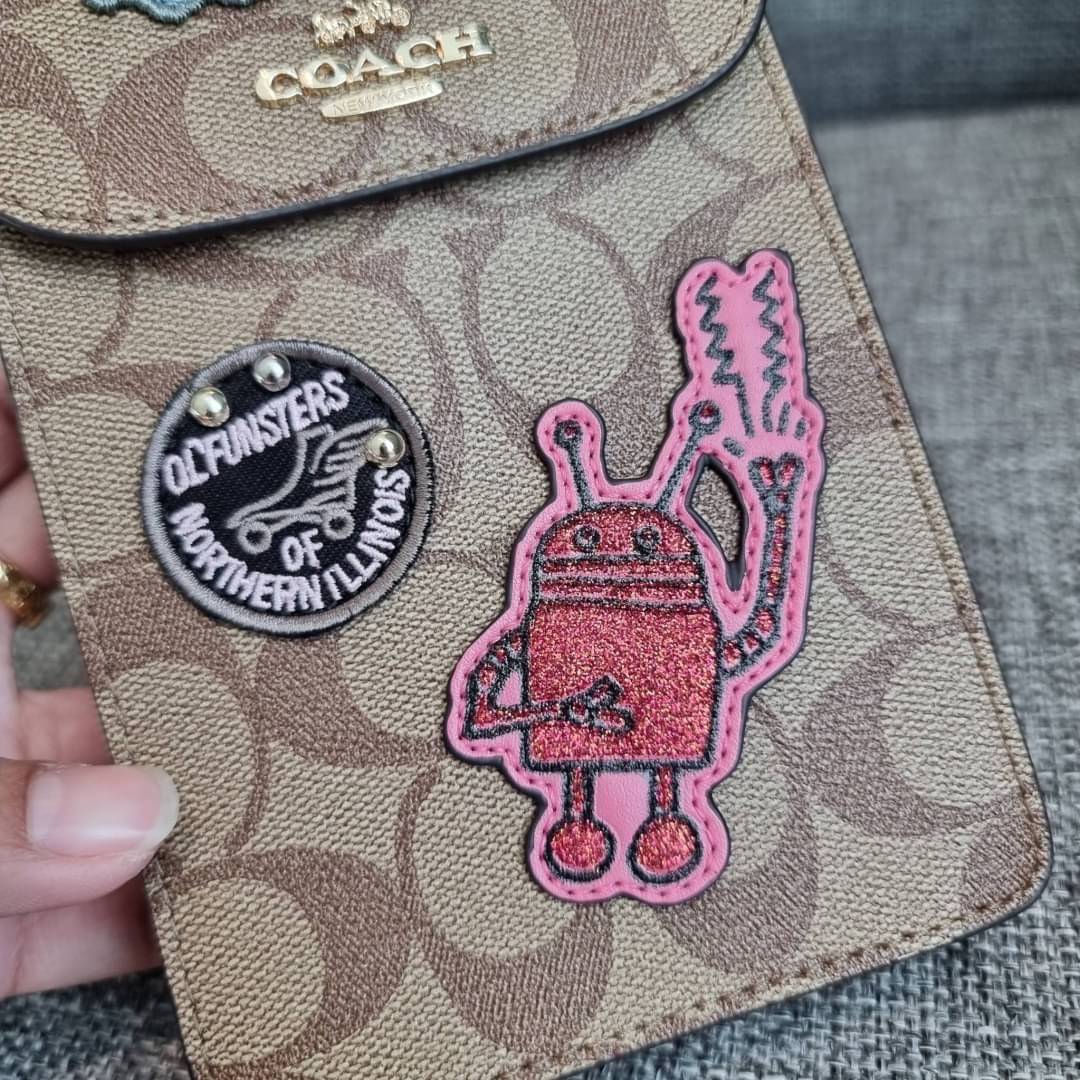 COACH NORTH/SOUTH PHONE CROSSBODY IN SIGNATURE CANVAS F55636 F39955 สุดคลาสสิคกับกระเป๋าสะพายเอนกประสงค์ Case phone ใส่โทรศัพท์มือถือได้ทุกรุ่น ดีไซน์ลายเอกลักษณ์ วัสดุหนังแคนวาสเคลือบลาย ฝาและภายในเป็นหนังสังเคราะห์เรียบ เปิด-ปิดด้วยกระดุม สายสะพายยาวประ