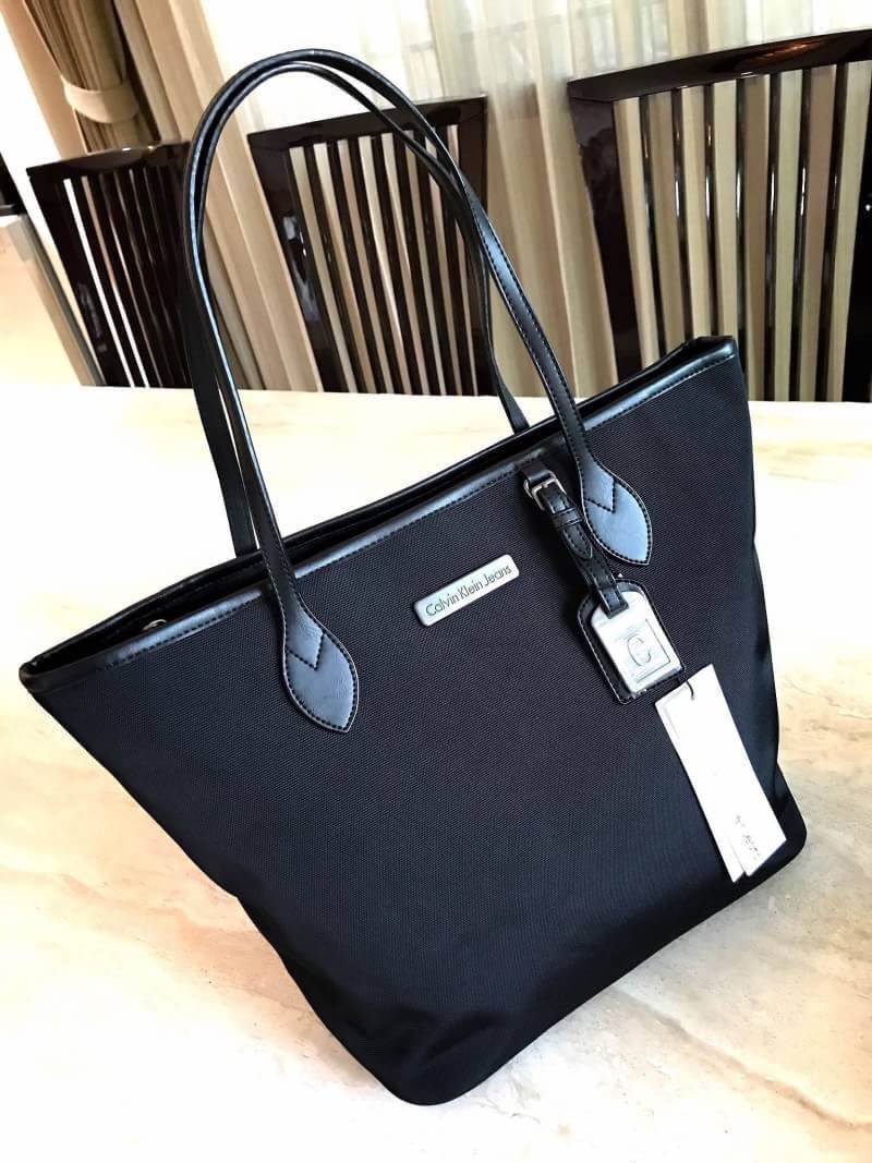 CALVIN KLEIN" JEANS TOTE BAG กระเป๋าสะพาย Calvin Klein Jeans Limited Edition จาก Calvin Klein Jeans วัสดุ Polyester คุณภาพดีเนื้อหนาน้ำหนักเบา ด้านหน้าประดับโลโก้ Calvin Klein Jeans พร้อม TAG ห้อยที่หูหิ้วดูมีดีเทล เปิดปิดด้วยซิปสะดวกใช้ หัวซิปโลโก้แ