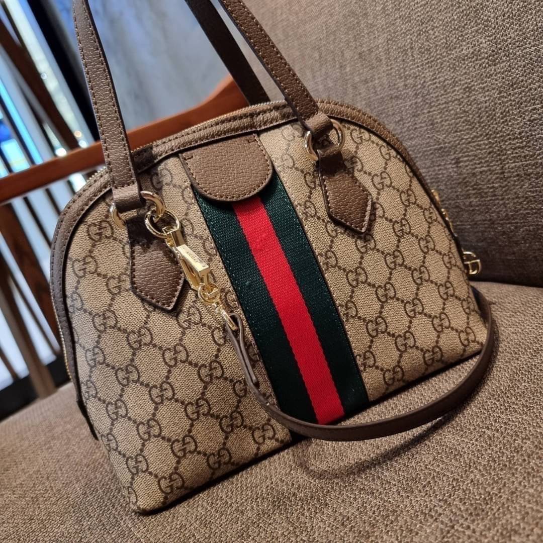 GC CLASSIC SATCHEL BAG กระเป๋าถือ/สะพายทรงโดม รุ่นหายาก สวยคลาสสิค แถมฟรี!! โบว์ผ้าลายแบรนด์ สำหรับตกแต่งหูกระเป๋า ผูกเป็นโบว์ หรือพันถนอมหูกระเป๋าก็เพิ่มดีเทลความหรูได้ วัสดุหนังแคนวาส ดีไซน์แถบคาดโดดเด่น เปิด-ปิดกระเป๋าด้วยซิป หัวซิปตัว G อะไหล่สีทอง เล