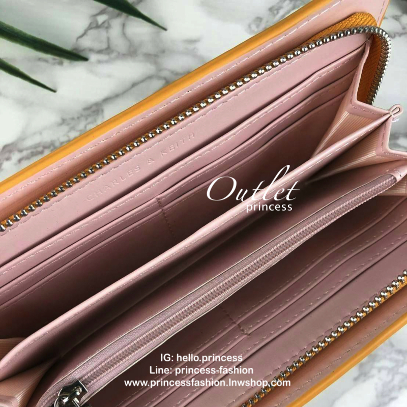CHARLES & KEITH CLASSIC ZIP AROUND WALLET กระเป๋าเงินใบยาวซิปรอบ มีสายคล้องมีสีเข้ากระเป๋า 1 เส้น ใช้งานง่ายมากๆ คล้องมือก็เก๋ ด้านหน้าปั๊มโลโก้แบรนด์ เปิดปิดด้วยซิปรอบ ที่สายคล้องมือแต่งหมุดสีสวยเด่น ถอดสายได้ จุบัตรได้ 12 ใบ มีช่องซิปใส่เหรียญและช่องใส่