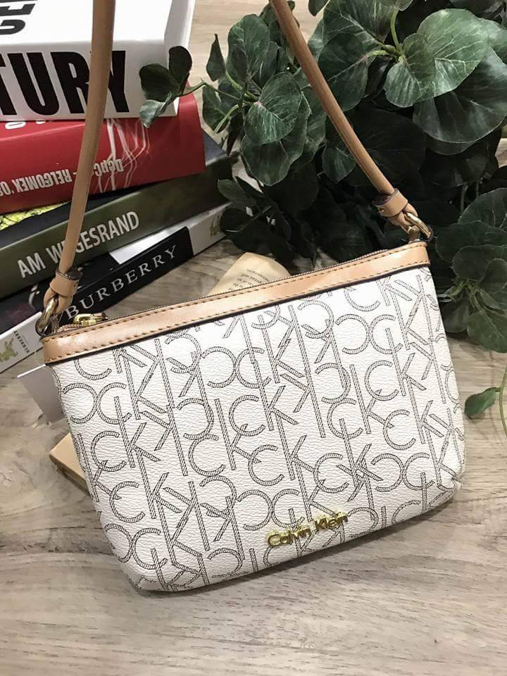 Calvin Klein Cross Body Bag กระเป๋าสะพายรุ่นใหม่ล่าสุดหนังสวย สกรีนลาย Signature แบรนด์รอบใบ ประดับโลโก้แบรนด์ สีทองด้านหน้า เปิดปิดด้วยซิป น้ำหนักเบา ภายใน โล่งกว้าง มีช่องใส่บัตร และช่องซิป ใส่ iphone+ ได้ มาพร้อมสายสะพายยาว ขนาดกำลังน่ารัก สะพายคล่องตั