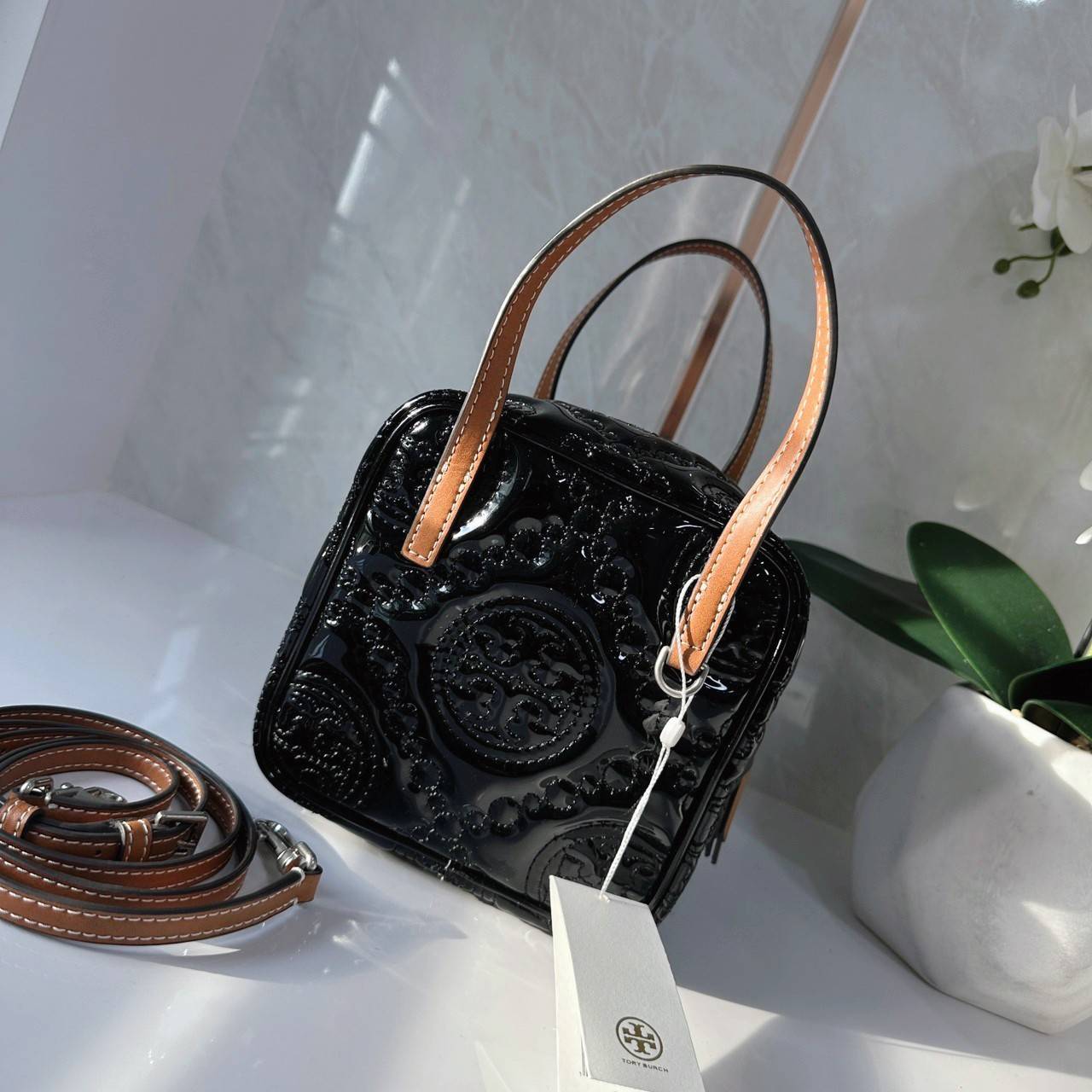 Tory Burch T Monogram Embroidered Patent Cube คอลเลคชั่นใหม่ รุ่นลิมิเต็ดรูปทรงใหม่ T Monogram สุดcube วัสดุหนังแท้ เปิด-ปิดด้วยซิป ภายในกว้าง มีช่องแยก 1 ช่อง สามารถใส่โทรศัพท์มือถือได้ทุกรุ่น สามารถถือหิ้วหรือสะพายได้ สายสามารถถอดและปรับระดับได้คะ