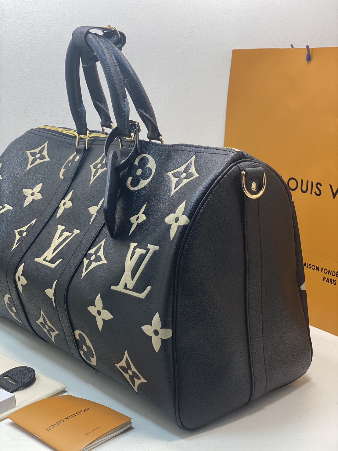 TOP ORI หนังแท้ | LV Keepall Bandoulière 45 bag กระเป๋าสะพายใบใหญ่ หนัง Empreinte ลาย Monogram Flower และสัญลักษณ์ LV ขนาดโอเวอร์ไซส์โทนสีอ่อน หนังโทนสีกลมกลืนกันแมตช์กับฮาร์ดแวร์สีทองบริเวณแถบด้านข้าง