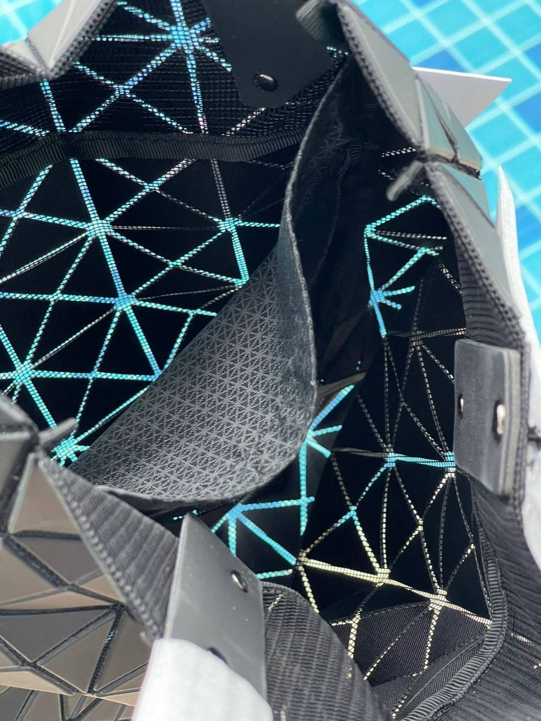 Baobao Issey Miyake Prism Kangaroo tote bag กระเป๋าถือทรงโท้ทที่ประดิษฐ์ขึ้นอย่างเชี่ยวชาญในญี่ปุ่น มาพร้อมแผงเรขาคณิตสำหรับการออกแบบที่ได้รับแรงบันดาลใจจากกระดาษพับ ซิลลูเอทอันเป็นเอกลักษณ์นี้ปิดท้ายด้วยสายรัดแบบอสมมาตร มีการพัฒนาโครงสร้างทรงสามเหลี่ยมเพ