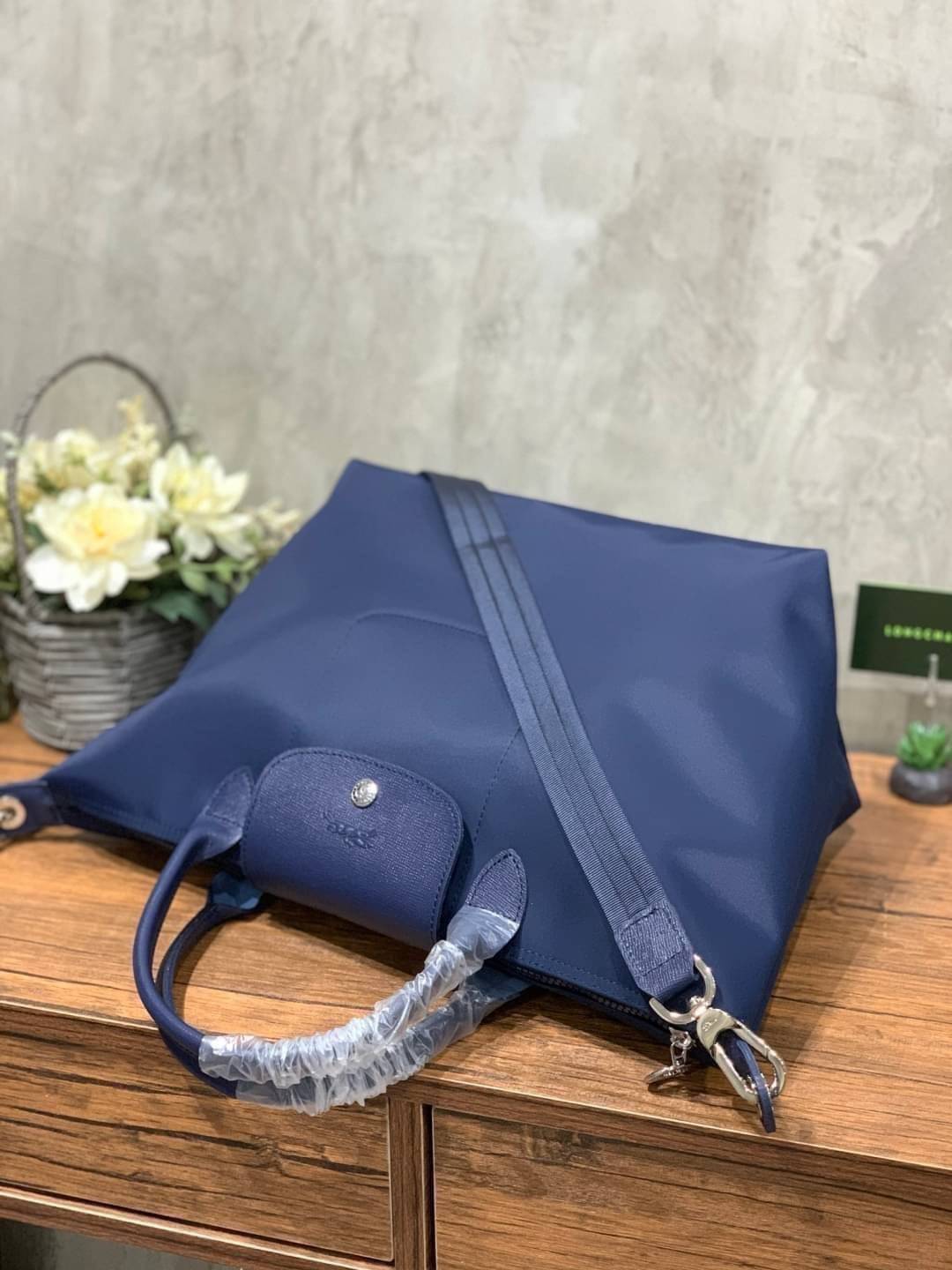 Longchamp Le Pliage Neo Size M มาพบกับกระเป๋ารุ่นยอดนิยม ที่สาวๆ ต้องมีไว้เก็บไว้สักใบ กระเป๋าโท้ทใบนี้ มาพร้อมกับสีที่มีสไตล์เรียบง่าย มีสายสะพายยาวช่วยให้คุณสามารถสะพายไหล่ได้อย่างสบาย ในขณะที่ที่ปิดแบบซิปช่วยให้คุณมั่นใจได้ว่าของด้านในมีความปลอดภัย Le 