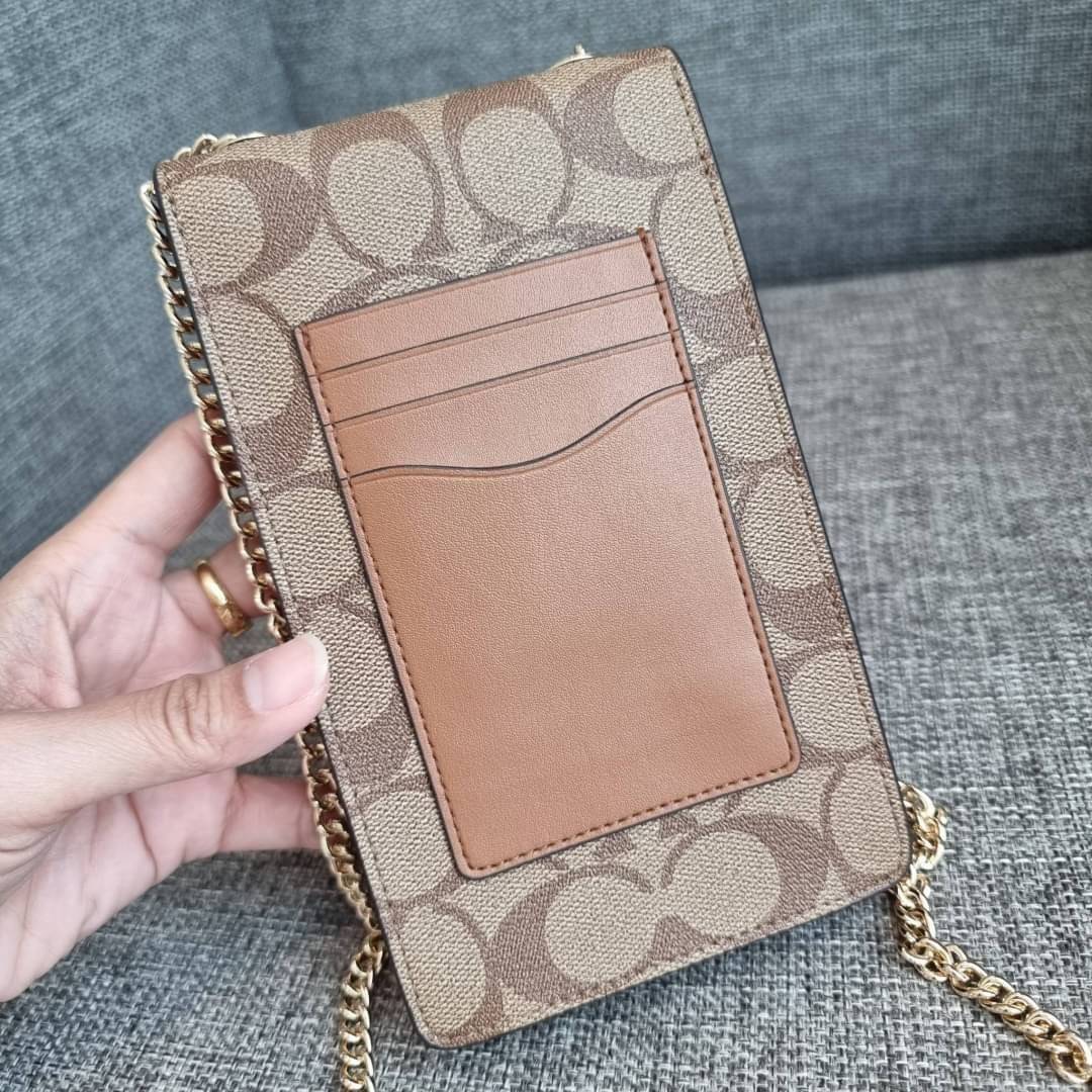 COACH NORTH/SOUTH PHONE CROSSBODY IN SIGNATURE CANVAS F55636 F39955 สุดคลาสสิคกับกระเป๋าสะพายเอนกประสงค์ Case phone ใส่โทรศัพท์มือถือได้ทุกรุ่น ดีไซน์ลายเอกลักษณ์ วัสดุหนังแคนวาสเคลือบลาย ฝาและภายในเป็นหนังสังเคราะห์เรียบ เปิด-ปิดด้วยกระดุม สายสะพายยาวประ