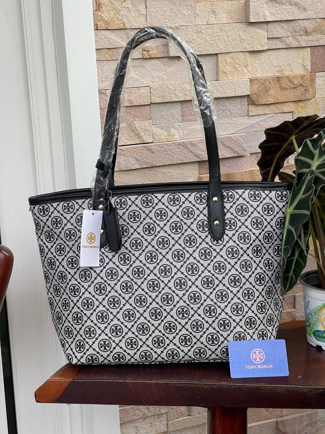 OUTLET 】Tory burch T Monograme Large shopping bag กระเป๋าสะพายใบไหล่ใบใหญ่ โดยตัวกระเป๋าทำมาจากผ้าแคนวาสเคลือบผิวด้านทนต่อรอยขีดข่วนได้เป็นอย่างดี ขนาดที่ใหญ่สามารถใส่ได้ทั้งเอกสารและสัมภาระต่างๆ พร้อมด้วยซิปปิดกระเป๋าด้านบนจึงเป็นอีกรุ่นที่เหมาะกับสาวออฟ