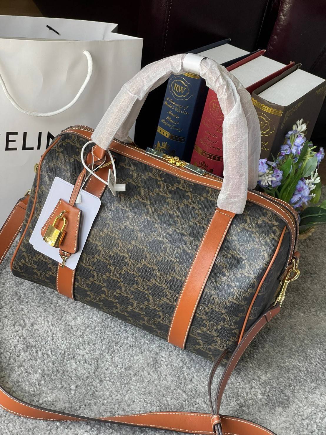 VIP 】CELINE BOSTON BAG IN TRIOMPHE CANVAS AND TAN ลวดลาย Triomphe Canvas Collection เป็นที่นิยมตลอดกาล มาในรูปแบบกระเป๋าทรงหมอนที่ได้รับความนิยมแบบทุกยุคทุกสมัย ซึ่งเป็นรูปทรงที่มีความคลาสสิก ดูดีแบบไม่มีตกยุค มาพร้อมขนาดที่ง่ายต่อการพกพา จัดเก็บหรือหยิบข