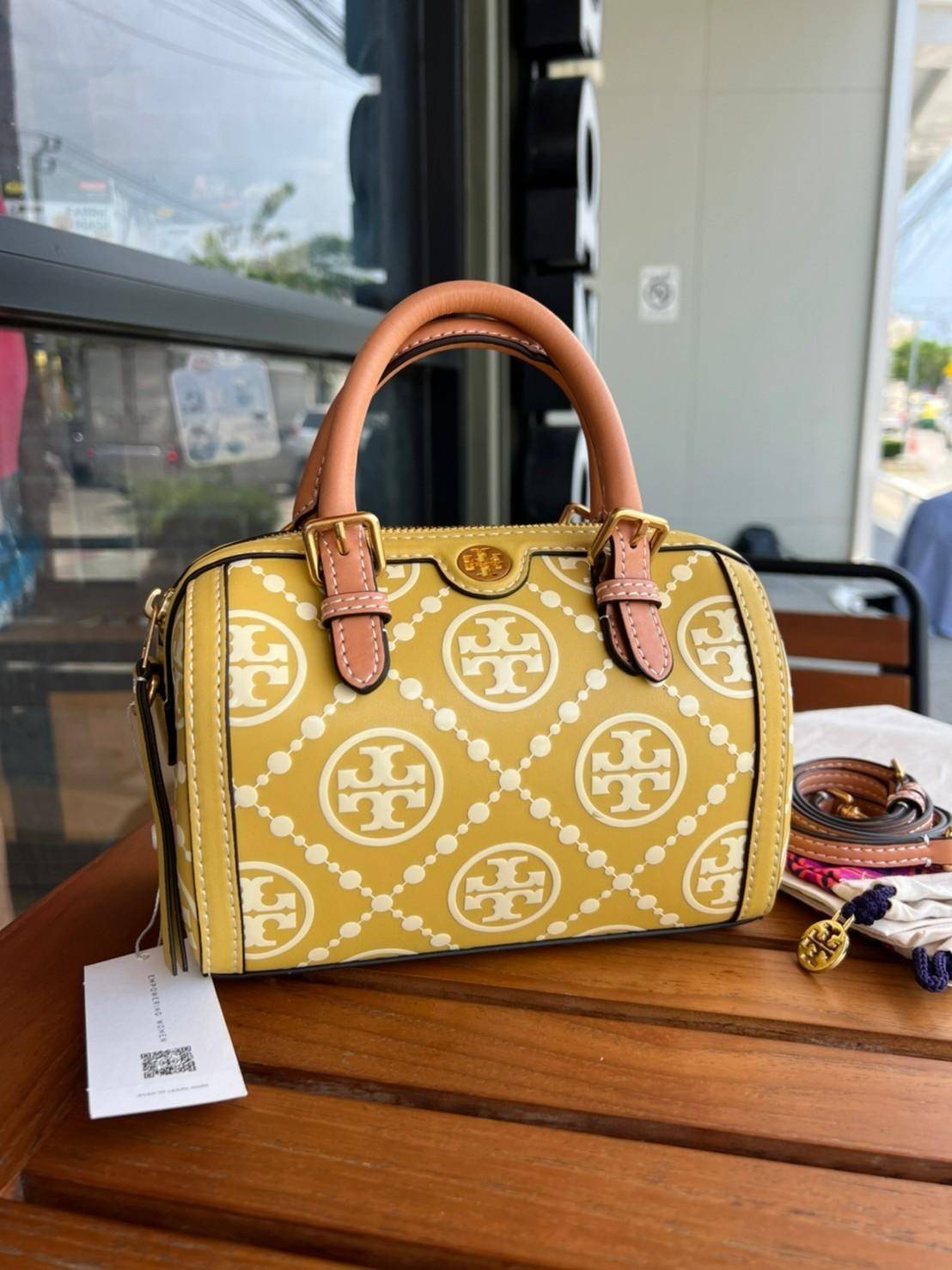 Tory Burch T-Monogram Mini Embossed Wine Bucket Bag / Tory Burch Mini Bucket กระเป๋าถือหรือสะพายไหล่ ทรงหมอนขนาดเล็ก ประดับด้วยลวดลายอันเป็นสัญลักษณ์ของแบรนด์ ถูกประดิษขึ้นด้วยความพิถีพิถันวัสดุหนังอย่างดี ด้านในบุด้วยหนังไมโครซูแอคเนื้อนุ่มทำความสะอาดง่า