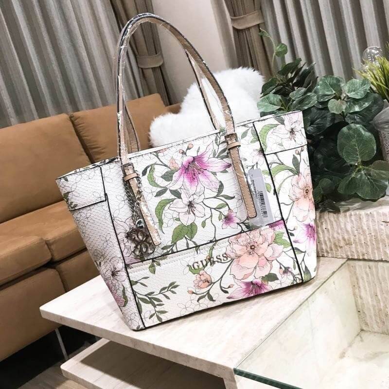 GUESS PRINTED FLOWERS SHOPPER BAG (SIZE L) กระเป๋าสะพายทรง TOTE หนังสวยอยู่ทรง ลายดอกไม้ ใบใหญ่กำลังดี น้ำหนักเบา ด้านหน้าประดับโลโก้แบรนด์ อะไหล่เงินพร้อม พวงกุญแจแบรนด์ห้อยที่หูหิ้วถอด เเยกใช้ได้ หูหิ้วเลื่อนปรับระดับได้ เปิดปิดด้วยซิป ภายในกว้างจุได้เย