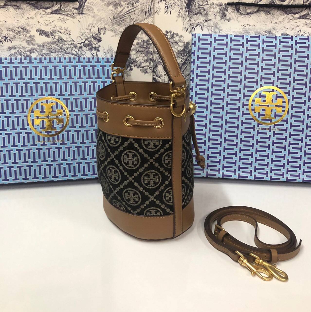 Mini : Tory Burch T Monogram Chenille Bucket Bag เปิดตัวอีกหนึ่งรุ่นกับกระเป๋าลาย T MONOGRAM รุ่นใหม่ล่าสุดจาก TORY BURCH พลาดไม่ได้กับโลโก้สุดคลาสสิก ลวดลาย T Monogram คือวัสดุ chenille หรือที่เรียกว่า ด้านไหมกำมะหยี่ มารังสรรค์ลงบนกระเป๋าBucketใบนี้ เป็