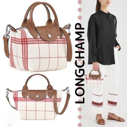 LONGCHAMP LE PLIAGE TORCHON Top handle bag - Red กระเป๋าถือขนาดเล็ก วัสดุผ้าฝ้าย อะไหลเงิน ตัดแต่งด้วยหนังวัวแท้ ผสมผสานแนวคลาสสิกแบบมินิมอลศิลปะการพับกระดาษแบบญี่ปุ่นดั้งเดิม