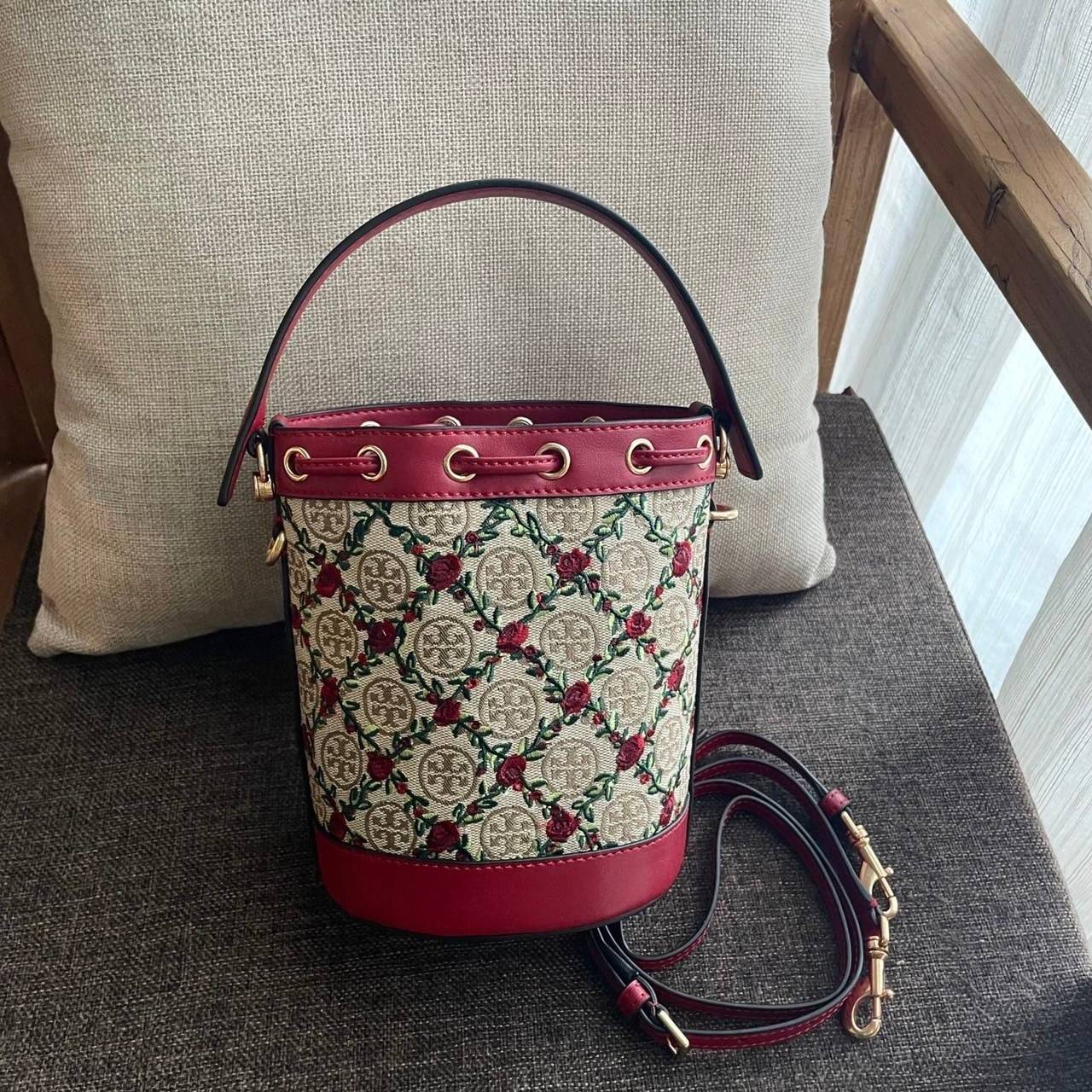Mini : Tory Burch T Monogram Embroidered Mini Bucket Bag Hazelnut กระเป๋าทรงถังขนาดเล็ก เป็นแพทเทิร์นคลาสสิคที่ได้รับแรงบันดาลใจจากการควิลท์แบบดั้งเดิมของเพนซิลเวเนีย คอลเล็คชั่นบอกเล่าความมีสไตล์เหนือกาลเวลา ลายดอกกุหลาบสีแดงลายปักษ์ วัสดุผ้าสว๊อตซ์วินเท