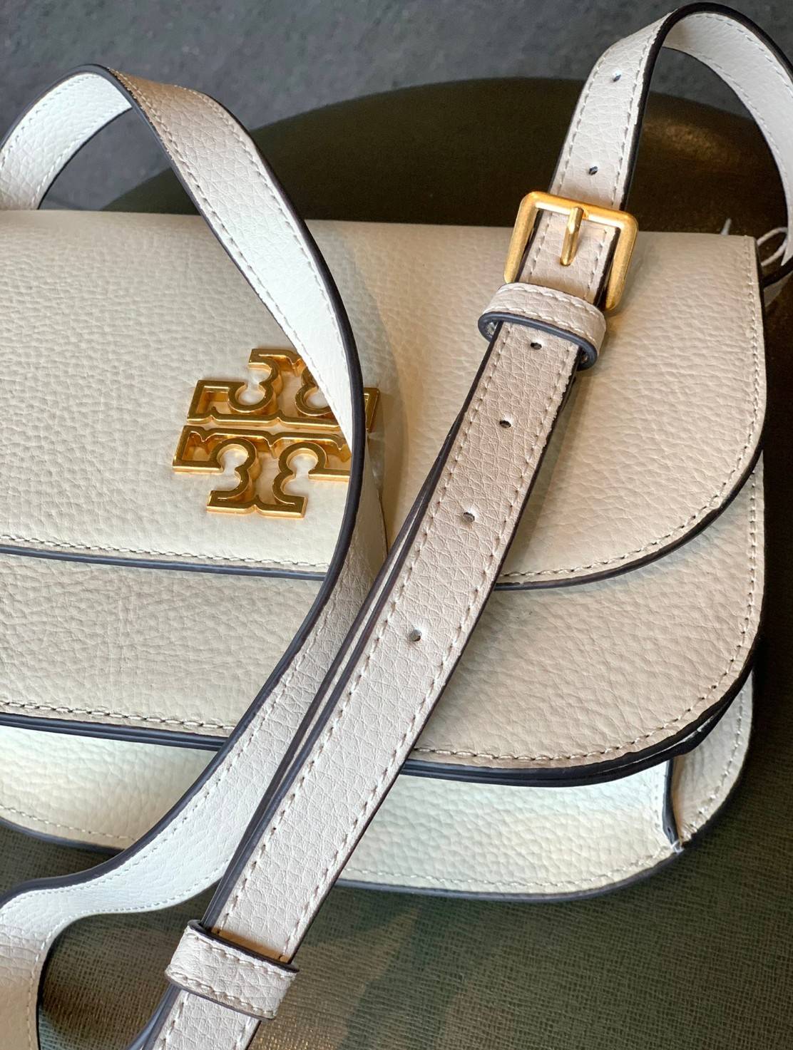 TORY BURCH BRLTTEN SMALL SADDLE BAG / Tory Burch Britten Flap Shoulder Bag กระเป๋าสะพายข้าง วัสดุหนังแกะแท้ ด้านหน้าประดับโลโก้แบรนด์ เปิด-ปิดกระเป๋าแบบกระดุมแป็กแม่เหล็กแน่นหนา ภายในมีช่องหลัก ใส่กระเป๋าเงินใบกลาง มือถือได้ทุกรุ่น มีช่องแยกใส่ของจุกจิกอี