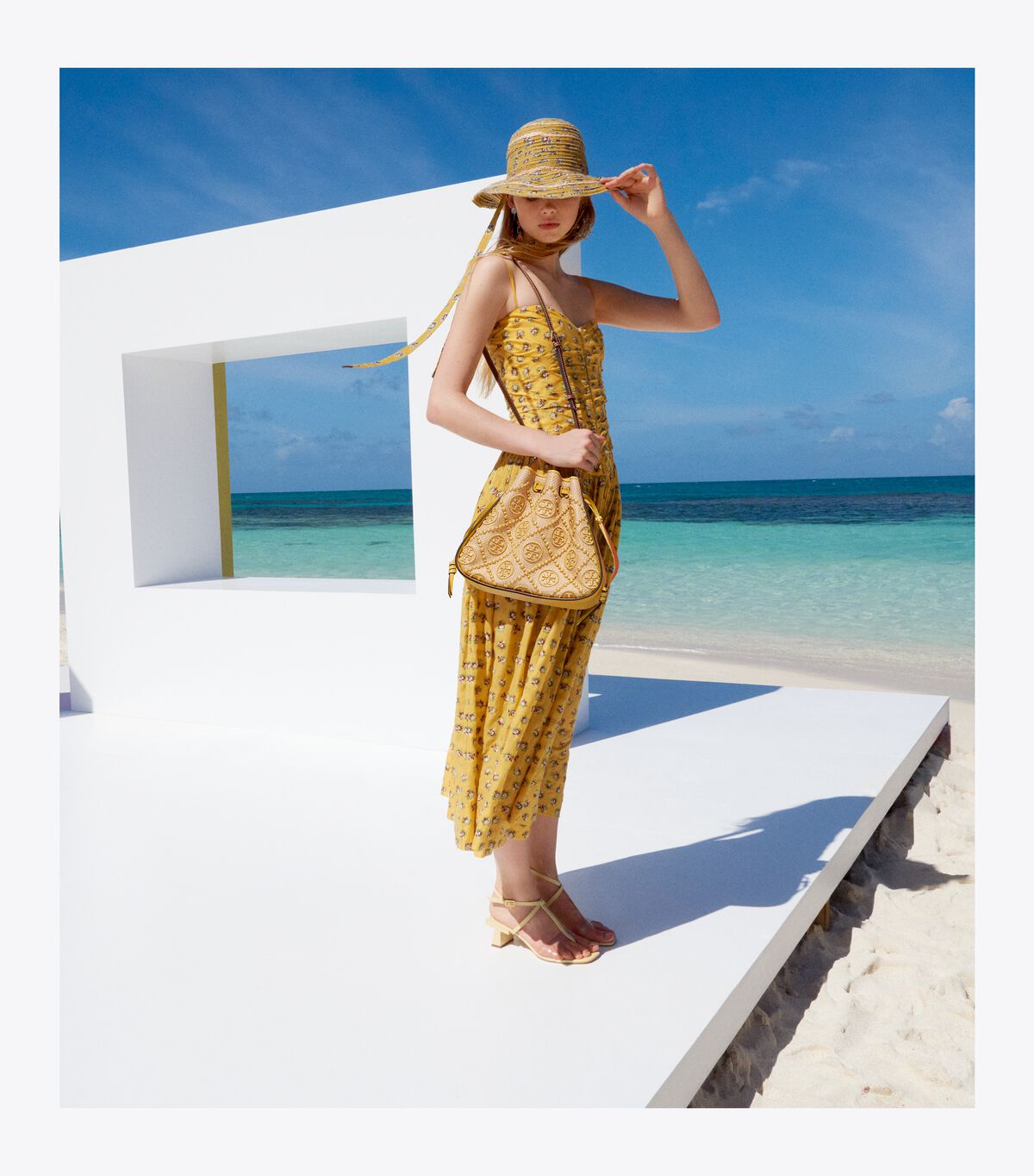 TORY BURCH T Monogram Straw Bell Bag กระเป๋าสะพายข้างรุ่นคลาสสิกที่ได้แรงบันดาลใจจากการควิลท์แบบดั้งเดิมของเพนซิลเวเนีย คอลเลกชันบ่งบอกถึงความมีสไตล์เหนือกาลเวลา รูปทรงเรียวโดดเด่น ปักทอลายแบรนด์อย่างสวยงาม เปิด ปิดด้วยเชือกรูด ด้านในช่องโล่งกว้าง ซับในผ้