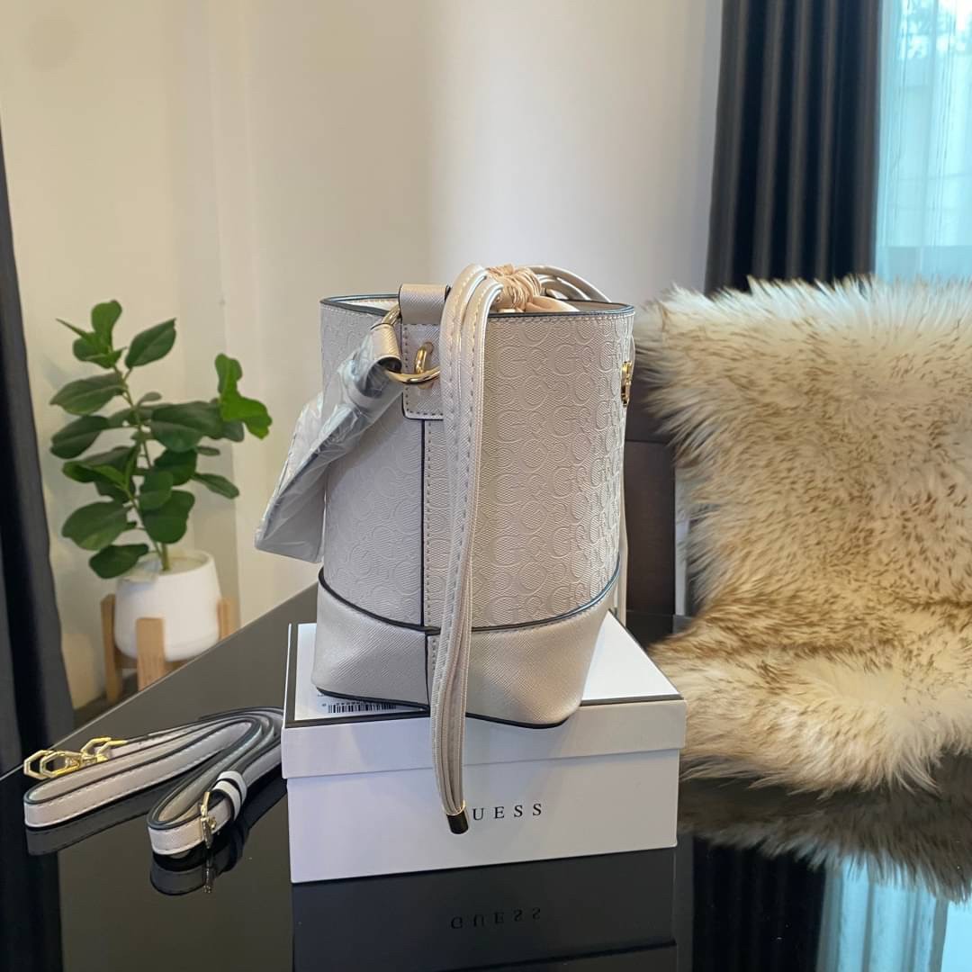 Guess Agata Bucket Handbag กระเป๋ารุ่นใหม่ล่าสุดทรงถังสุดน่ารัก พิมพ์ลายรอบใบ วัสดุ Saffiano PU คุณภาพดี นิ่ม น้ำหนักเบา ด้านหน้าประดับด้วยโลโก้แบรนด์สวยโดดเด่น เปิด-ปิดด้วยเชือกหนังใช้หูรูดปลายเชือกประดับอะไหล่ทองสะดวกใช้ ด้านในโล่งกว้างมีช่องเล็กสำหรับใ