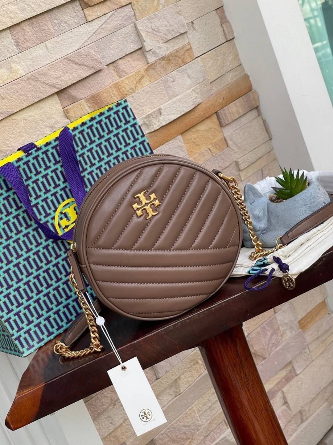 Tory burch Kira Cheron Circle Crossbody กระเป๋าสะพายคาดลำตัวรุ่นนี้โดดเด่นด้วยรูปทรงกลมสุดชิค ขนาดกะทัดรัด พร้อมด้วยหนังกระเป๋าที่ทำจากหนังแท้คุณภาพดี เพราะ Kira Chevron เป็นรุ่นที่ตอบโจทย์และครองใจสาว ๆ ได้อย่างแท้จริง เนื่องจากมีดีไซน์เรียบหรู โดยทางแบร