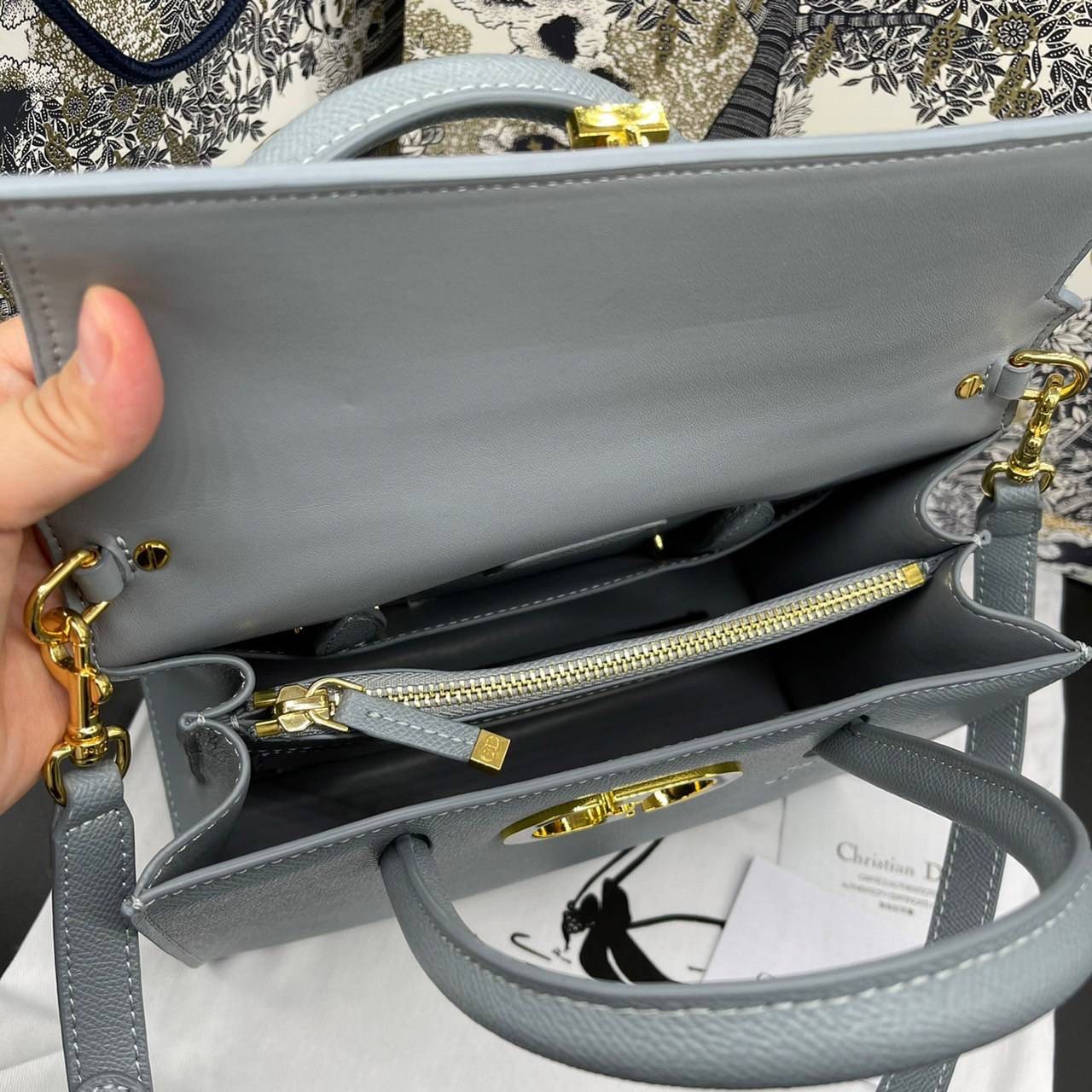 หนังแท้ DIOR Medium ST Honore Tote Collection Fall/Winter 2020-2021 มาในรูปแบบกระเป๋าทรงสี่เหลี่ยมที่ได้มาตรฐาน ทำจากหนังลูกวัว (Calfskin) ลายเกรน ซึ่งสื่อถึงความหรูหราได้อย่างลงตัว ตัวด้ามจับ มีการเย็บเข้าด้านในของกระเป๋าเพื่อเพิ่มความแข็งแรงทนทาน ด้านหน