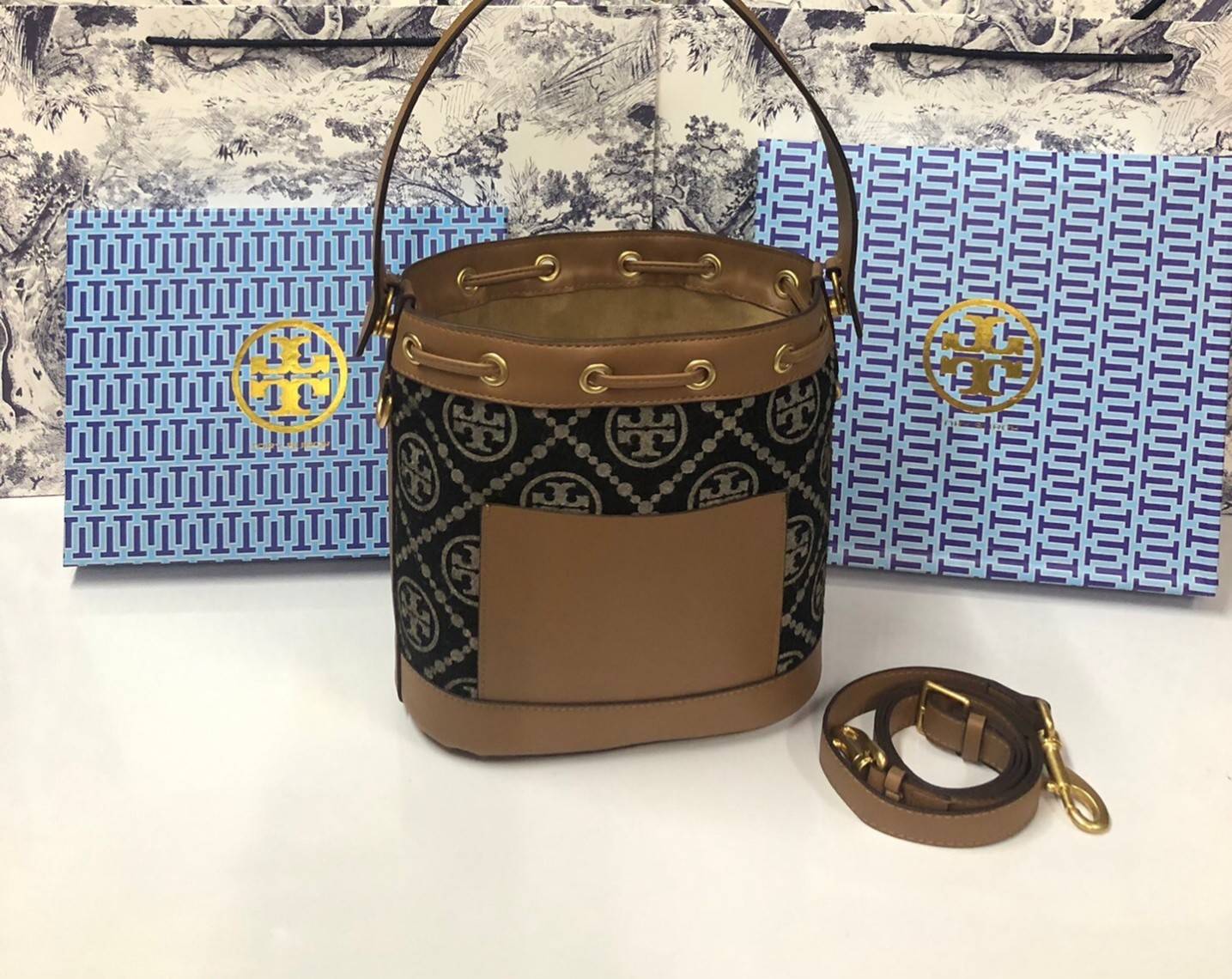 Medium : Tory Burch T Monogram Chenille Bucket Bag เปิดตัวอีกหนึ่งรุ่นกับกระเป๋าลาย T MONOGRAM รุ่นใหม่ล่าสุดจาก TORY BURCH พลาดไม่ได้กับโลโก้สุดคลาสสิก ลวดลาย T Monogram คือวัสดุ chenille หรือที่เรียกว่า ด้านไหมกำมะหยี่ มารังสรรค์ลงบนกระเป๋าBucketใบนี้ เ
