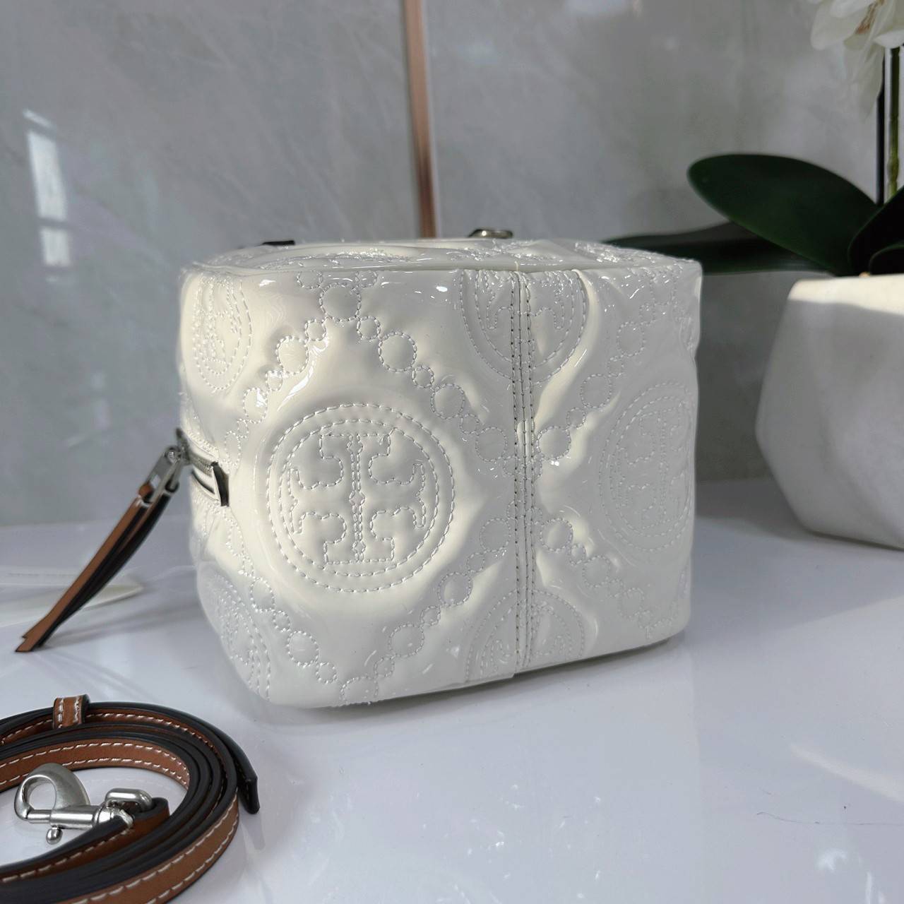 Tory Burch T Monogram Embroidered Patent Cube คอลเลคชั่นใหม่ รุ่นลิมิเต็ดรูปทรงใหม่ T Monogram สุดcube วัสดุหนังแท้ เปิด-ปิดด้วยซิป ภายในกว้าง มีช่องแยก 1 ช่อง สามารถใส่โทรศัพท์มือถือได้ทุกรุ่น สามารถถือหิ้วหรือสะพายได้ สายสามารถถอดและปรับระดับได้คะ