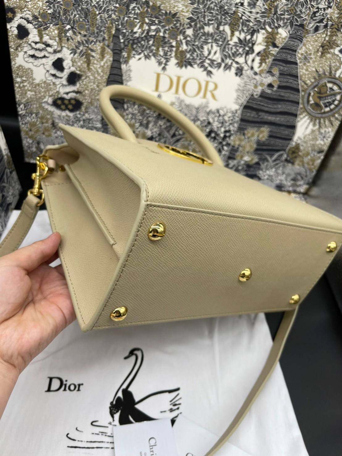 หนังแท้ DIOR Medium ST Honore Tote Collection Fall/Winter 2020-2021 มาในรูปแบบกระเป๋าทรงสี่เหลี่ยมที่ได้มาตรฐาน ทำจากหนังลูกวัว (Calfskin) ลายเกรน ซึ่งสื่อถึงความหรูหราได้อย่างลงตัว ตัวด้ามจับ มีการเย็บเข้าด้านในของกระเป๋าเพื่อเพิ่มความแข็งแรงทนทาน ด้านหน