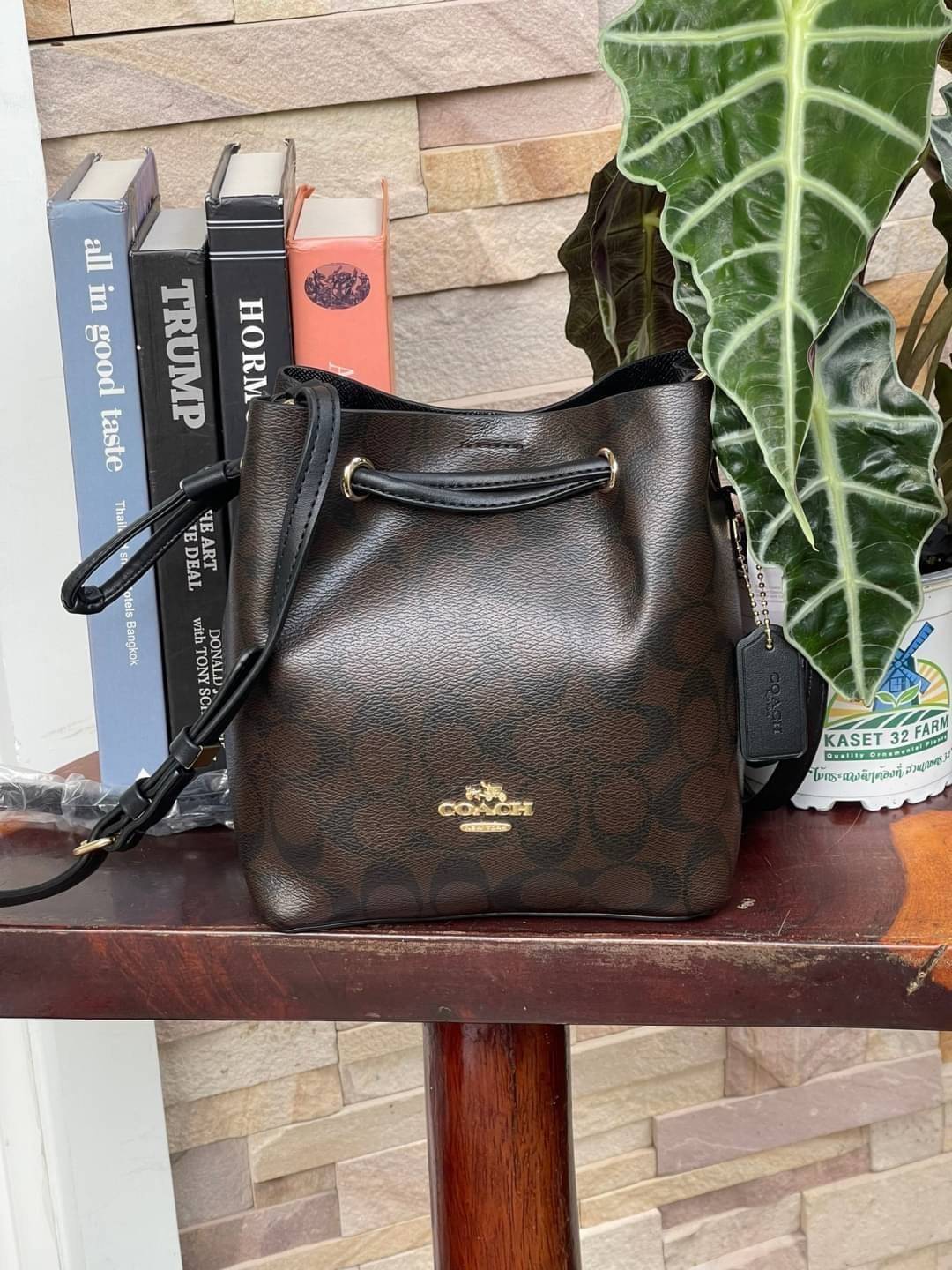 Coach Lena Crossbody Signature Bucket Bag กระเป๋าสะพายไหล่สุดคลาสสิกรุ่นนี้ เป็นรูปทรงถัง ที่สามารถจุของได้กำลังดี สำหรับสาวๆสายแฟชั่นที่ชอบรายละเอียดชิคๆ ดีไซน์เก๋ ด้วยรูปทรงของกระเป๋าที่ออกแบบมาให้ฐานเป็นรูปสี่เหลี่ยมทำให้กระเป๋ายังคงรูปทรงได้ง่าย มีสาย