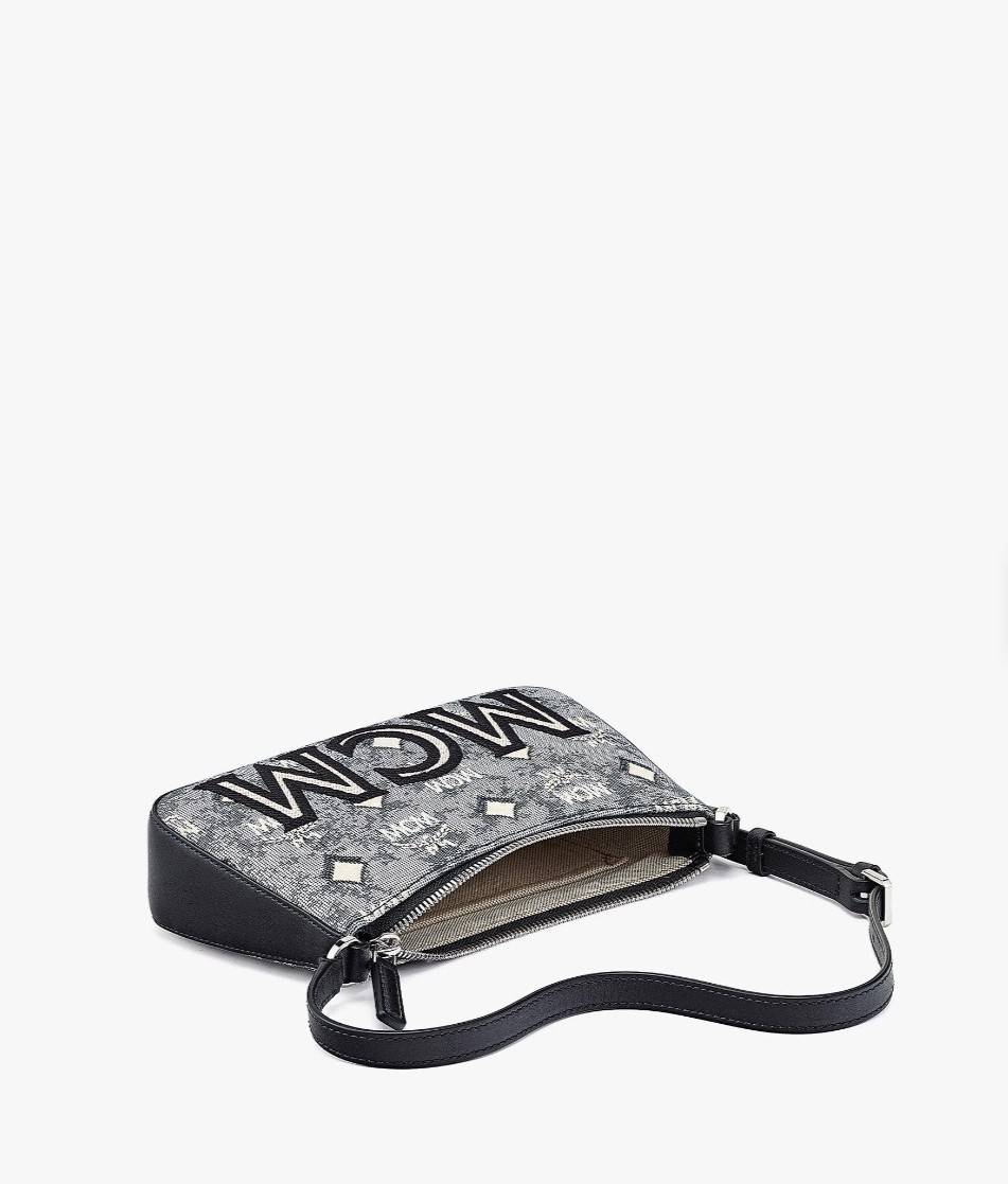 M.C.M MINI SHOULDER BAG IN VINTAGE JACQUARD MONOGRAM คอลเลคชั่นใหม่ล่าสุด โดดเด่นด้วยลายโมโนแกรม ถักทอบนผ้า woven jacquard กระเป๋าสะพายทรงพอชที่ไม่ธรรมดา มาพร้อมสายสะพายในตัว สามารถปรับใช้ได้ 2 แบบ สายยาวสะพายข้าง หรือจะนำสายเส้นกลางออกและปรับใช้สะพายไหล่