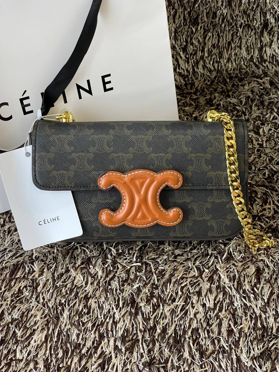 Celine Chain Shoulder Bag Cuir Triompe In Triompe เป็นกระเป๋าถูกประดิษฐ์ขึ้นในรูปทรงมินิมอล นับว่าเป็นกระเป๋าอีกหนึ่งรุ่นในซีรีส์ Triomphe ที่ได้รับความนิยมอย่างมาก โดยเป็นกระเป๋าสะพายไหล่ทรงสี่เหลี่ยมผืนผ้าที่อัดแน่นไปด้วยกลิ่นอายความคลาสสิกตามแบบฉบับของ