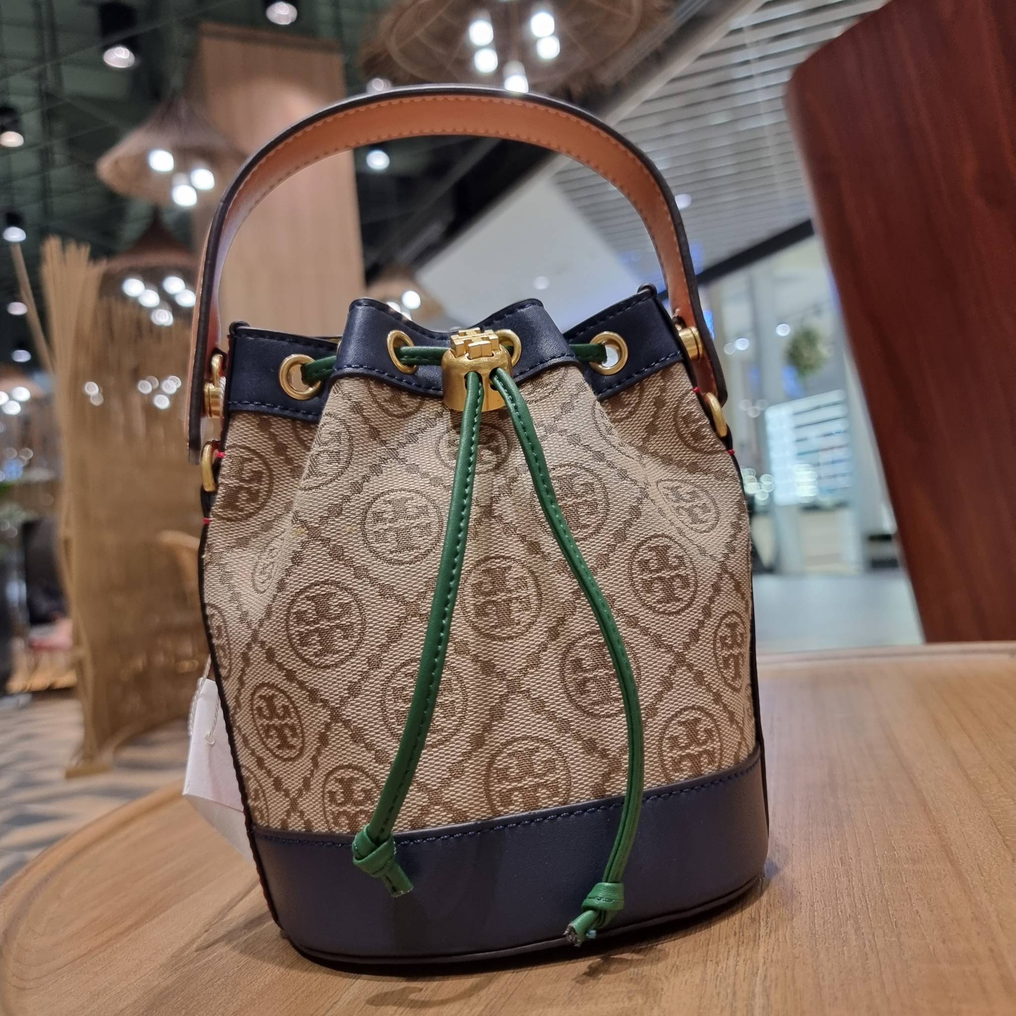 MINI : TORY BURCH T MONOGRAM COLOR-BLOCK JACQUARD MINI BUCKET BAG ใหม่ล่าสุด กับกระเป๋าบัคเก็ตทรงสวย ไซส์มินิ ในราคาน่ารัก โดดเด่นด้วยลวดลายเอกลักษณ์ ผสานลายคัลเลอร์บล็อค โทนสีตัดกันอย่างลงตัว ถักทอบนวัสดุ woven jacquard ลายคมชัด สลับส่วนของหนังแท้ ภายในเ