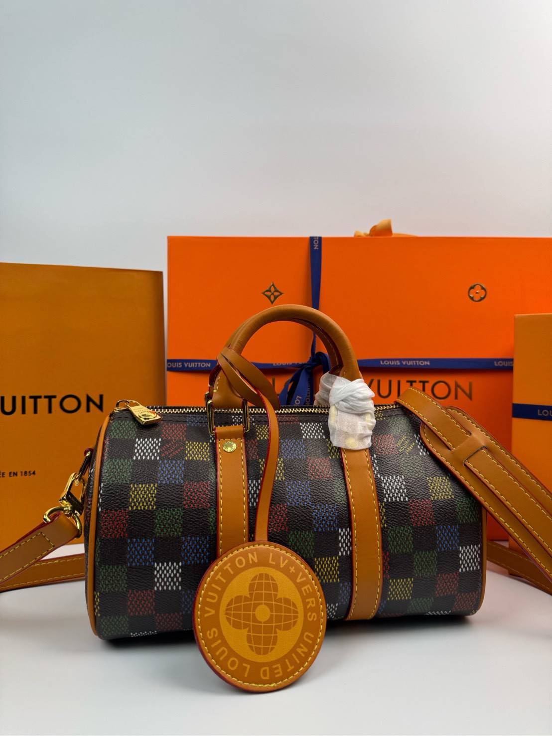 ORI หนังแท้ | LV Keepall Bandoulière 25 Bag กระเป๋าทรงหมอนซิตี้ ดีไซน์ใหม่จาก LV Vers Damier Ebene โดดเด่นที่ลายช่องสี่เหลี่ยมดุจระบายสีด้วยมือพิมพ์ลงบนลายตารางหมากรุก แต่งดีเทลหรูหราผสานอดีตเข้ากับปัจจุบันได้อย่างมีสไตล์