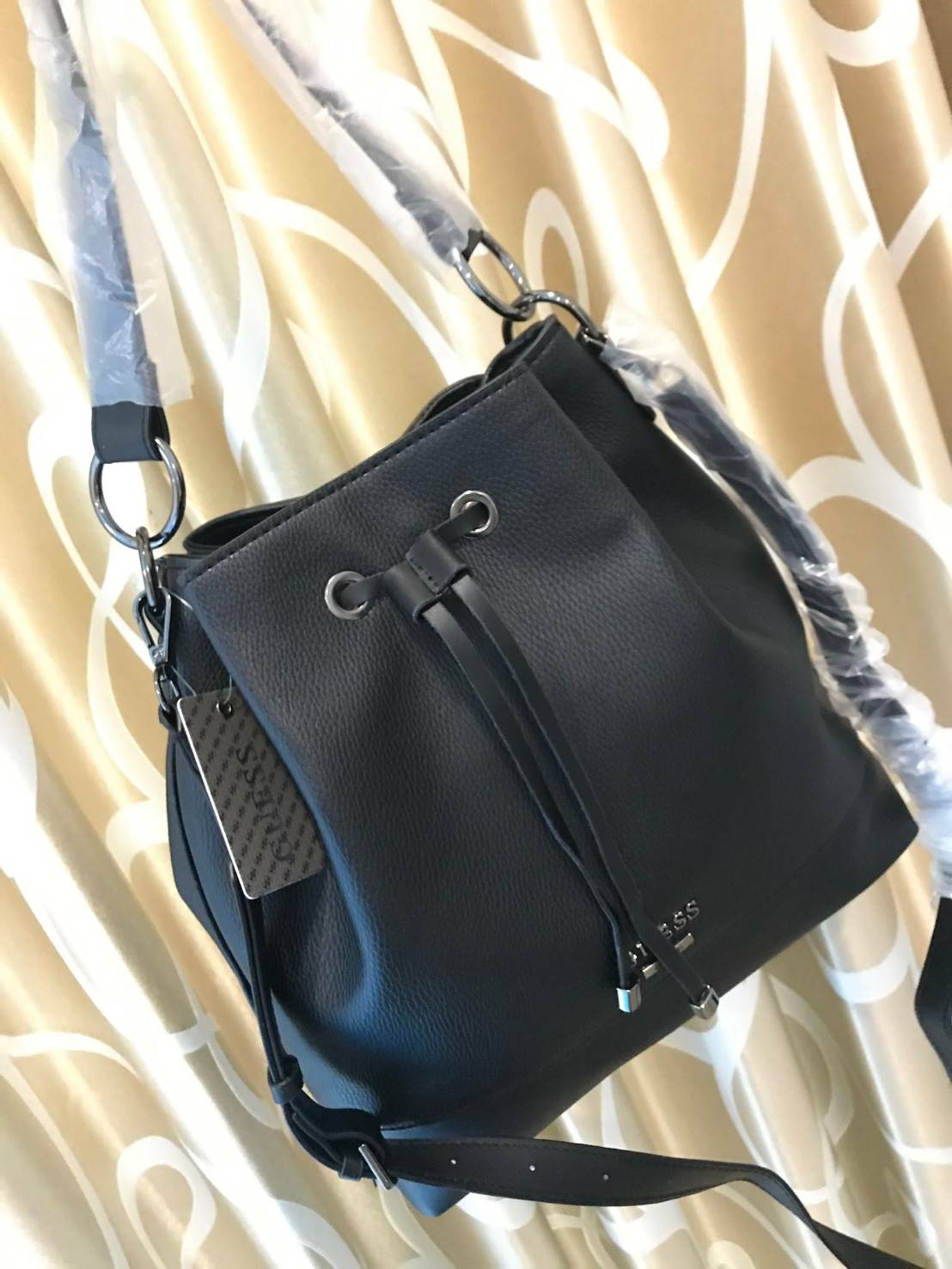 Guess Drawstring Bucket Bag With Strap GUESS. DRAWSTRING BUCKET BAG WITH STRAP กระเป๋าถือหรือสะพายแบรนด์ดังรุ่นยอดนิยม วัสดุหนังแกะสังเคราะห์แบบนิ่มสวยอยู่ทรง ด้านหน้าประดับโลโก้ เปิดปิดแบบ Drawstring ภายในกว้างมีช่องซิปและโลโก้ ใส่ ipad และของใช้ได้เยอะ 