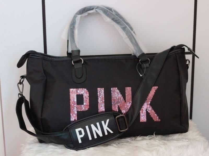 Victorias Secret PINK กระเป๋าสไตล์กระเป๋าเดินทาง หรือสะพายไปเล่นฟิตเนส ด้านหน้าจะมีตัวอักษร PINK เลื่อมสีชมพู เปิดปิดด้วยซิป ภายในมีช่องใหญ่ จุของได้เยอะ มีช่องใส่โทรศัพท์หรือของจุกจิก สามารถใส่เสื้อผ้าได้หลายชุด สายสะพายปรับระดับได้ และมีที่วางบ่าให้ด้วย