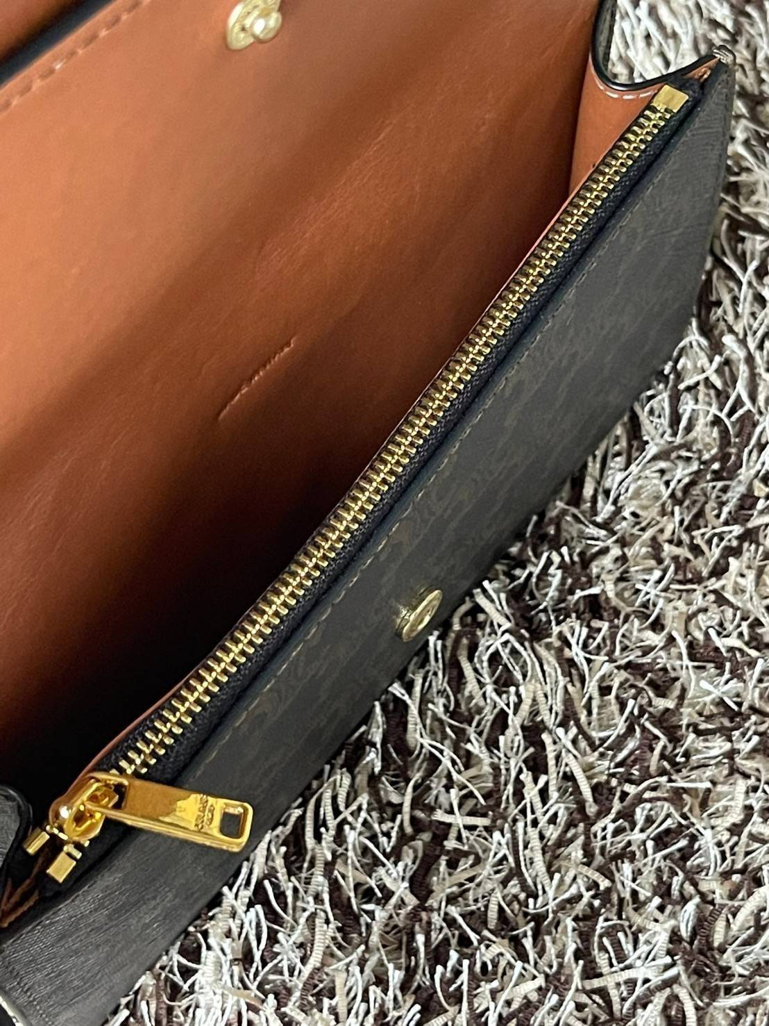 CELINE WALLET ON STRAP IN TRIOMPHE CANVAS กระเป๋าสะพายไหล่สุดเก๋ใบนี้ผลิตจากผ้าใบเคลือบอย่างดีพร้อมขอบหนังสีน้ำตาล กระเป๋ามีสายสะพายหนังสีน้ำตาลพร้อมฮาร์ดแวร์สีทอง ถอดสายออกเพื่อเป็นกระเป๋าถือทรงคลัชท์เปลี่ยนลุคช์ ลวดลายtriomphe ความเป็นแบรนด์ CELINE ได้อ